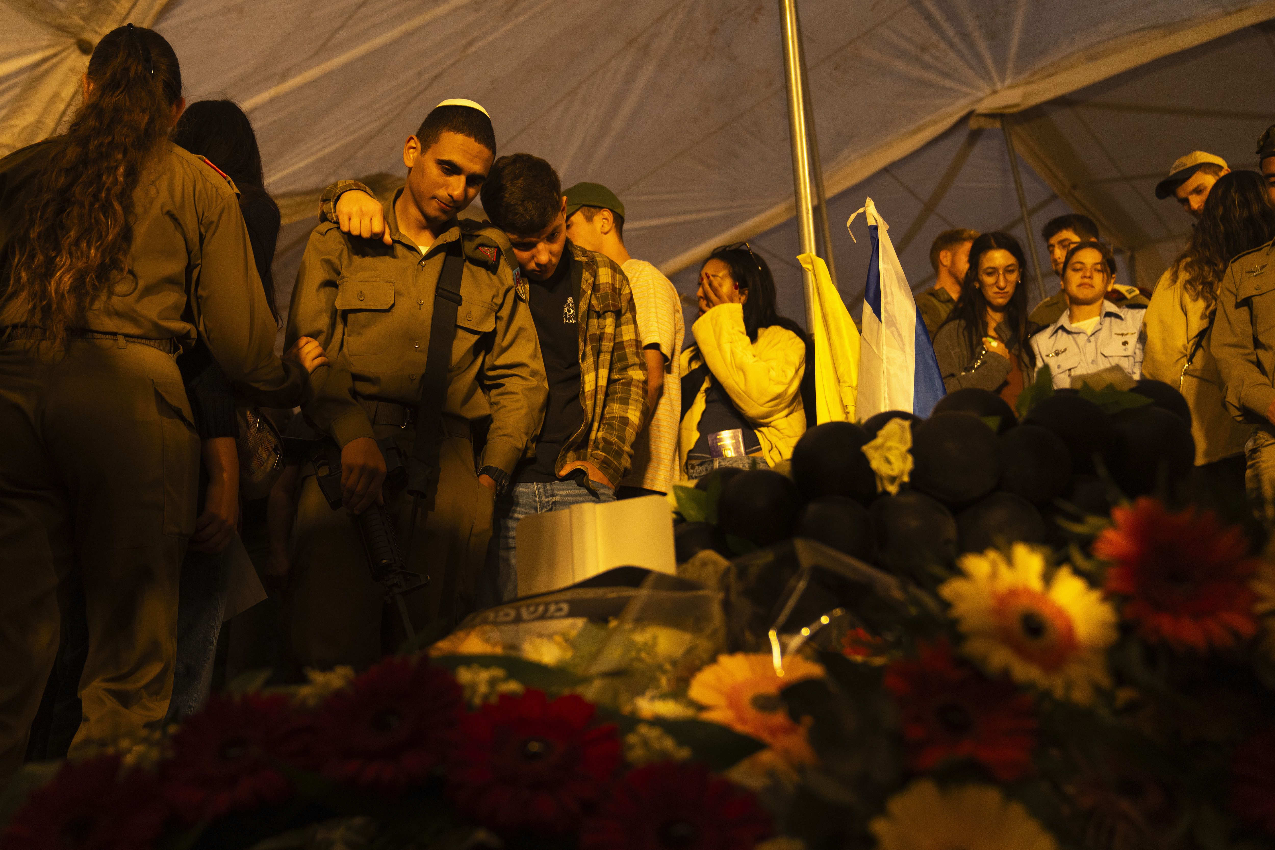 Israeli soldiers and relatives mourn during the funeral of captain Yogev Pazi, who was killed in Gaza, at the cemetery of Giv'ot Bar, southern Israel, Monday, Nov. 18, 2024. (AP Photo/Francisco Seco)