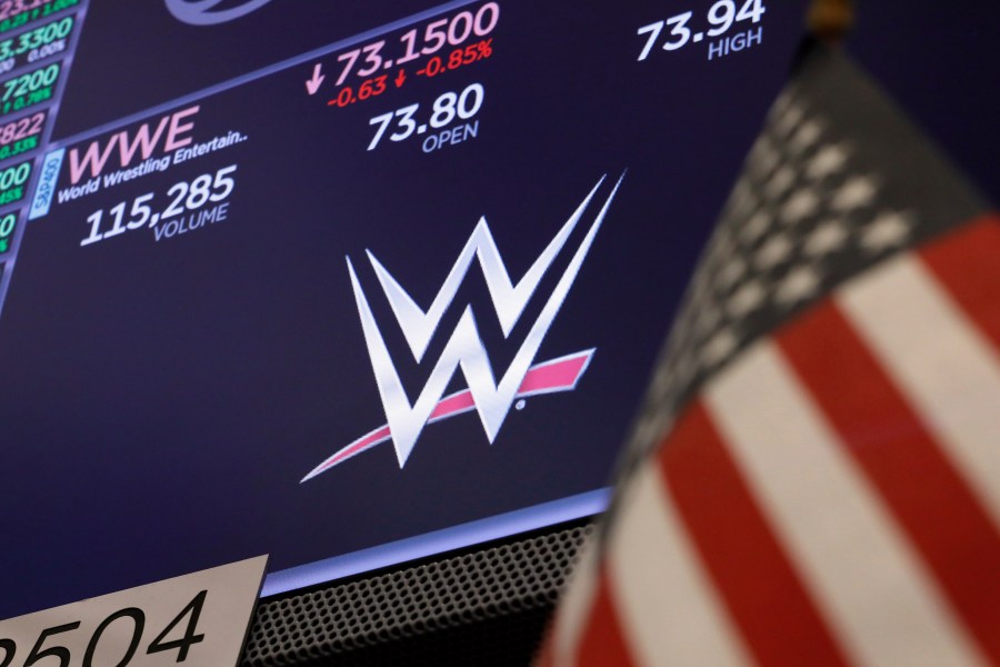 FILE - The logo for World Wrestling Entertainment, WWE, appears above a trading post on the floor of the New York Stock Exchange, Sept. 13, 2019. (AP Photo/Richard Drew, File)