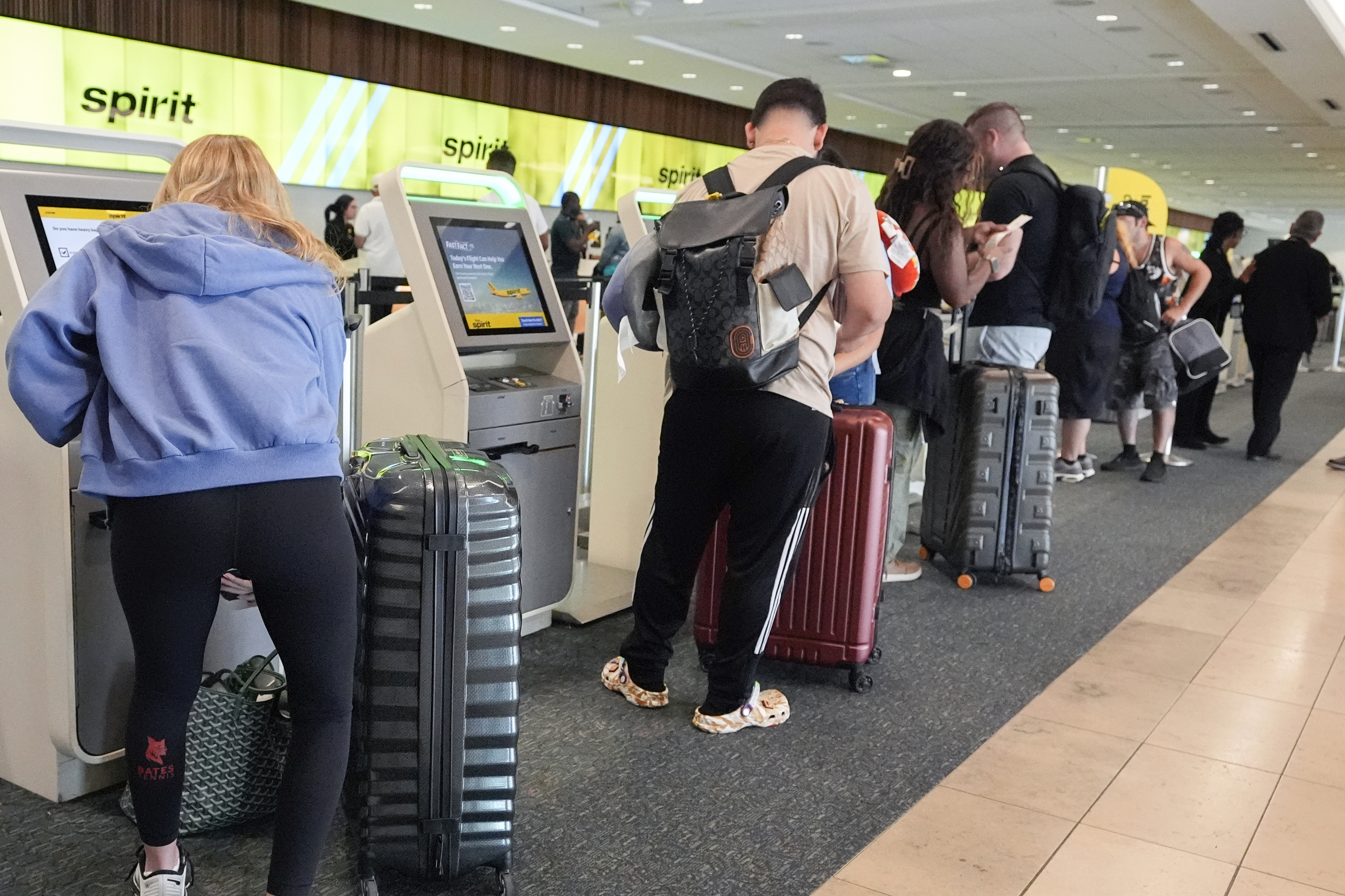 FILE - Airline passengers self check in at the Spirit airlines counter at Orlando International Airport on July 3, 2024, in Orlando, Fla. (AP Photo/John Raoux, File)