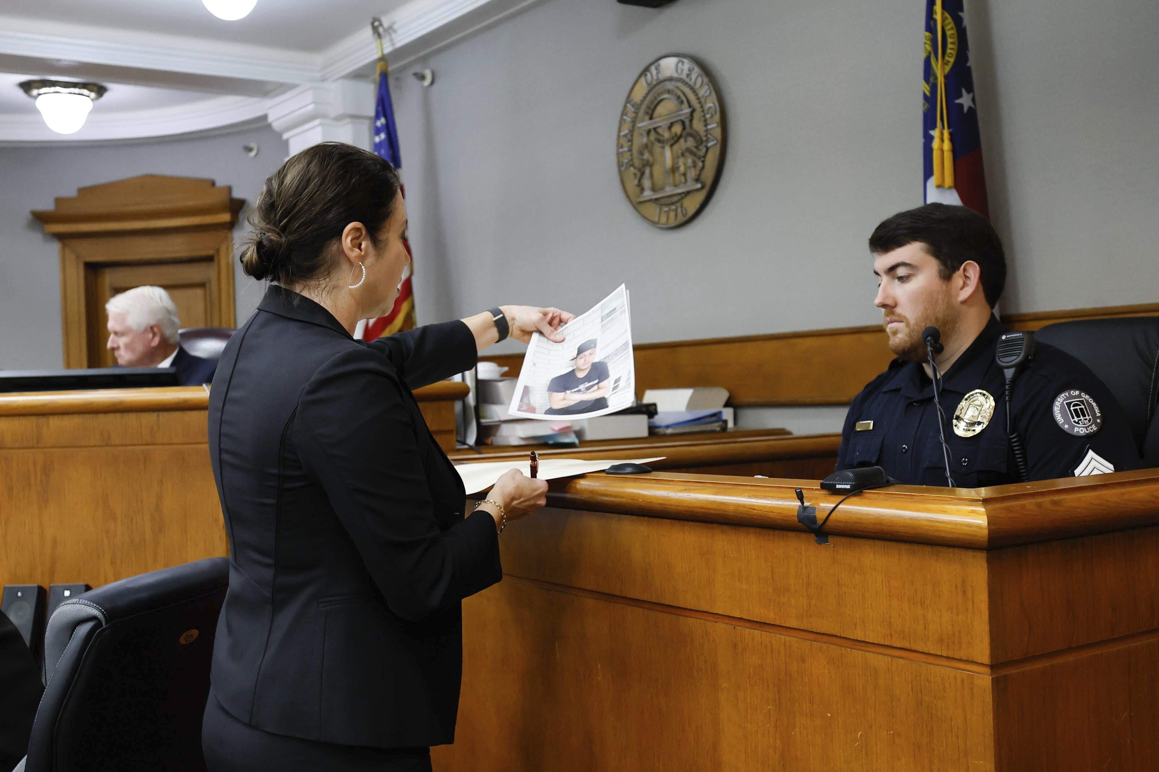 Prosecutor Sheila Ross shows a piece of evidence to University of Georgia Police Josh Epps during the trial of Jose Ibarra at Athens-Clarke County Superior Court on Monday, Nov. 18, 2024, in Athens, Ga. (Miguel Martinez/Atlanta Journal-Constitution via AP, Pool)