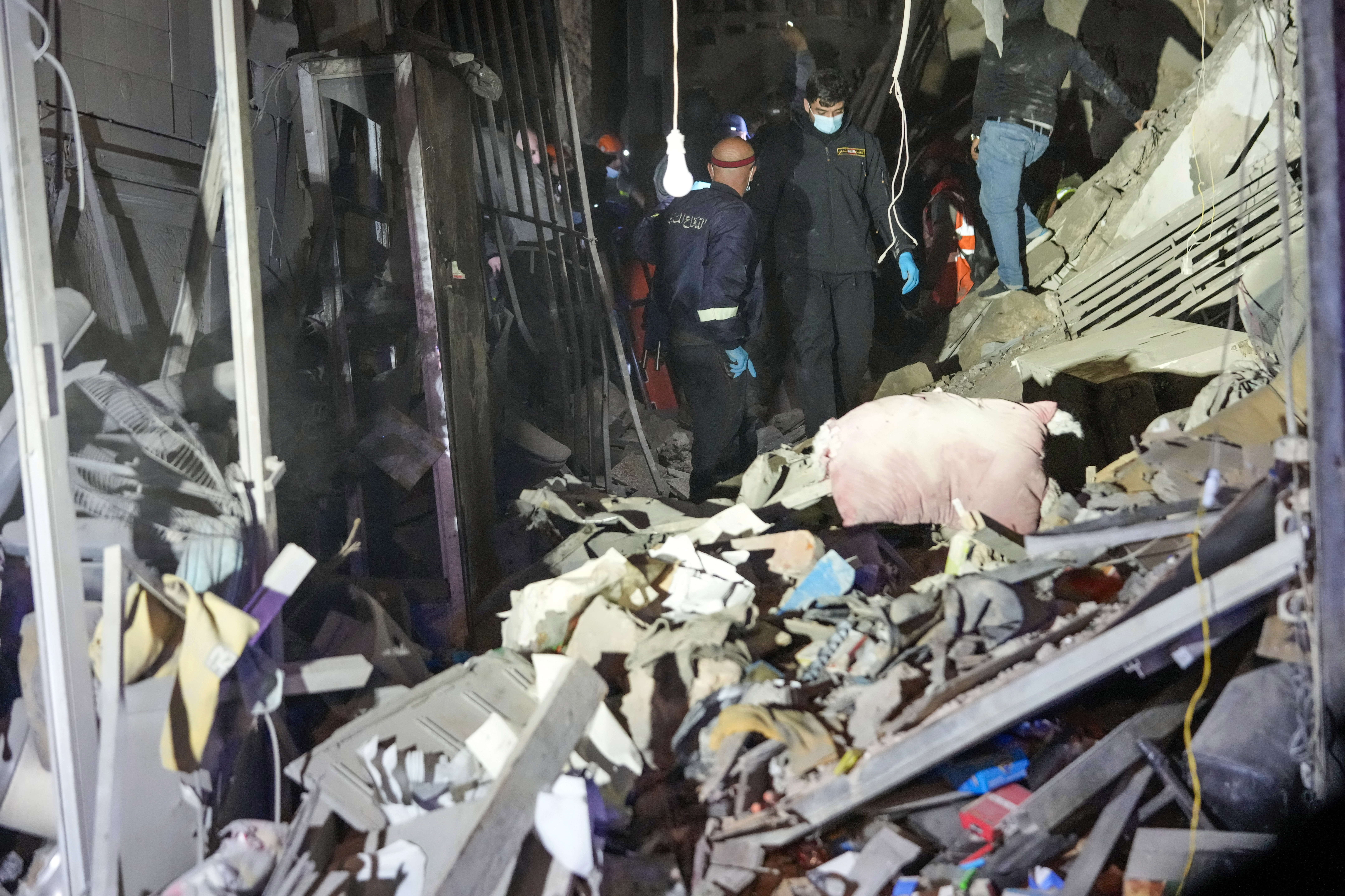 Rescue workers and residents search for victims at the site of an Israeli airstrike in Beirut, Lebanon, Monday, Nov. 18, 2024. (AP Photo/Hussein Malla)