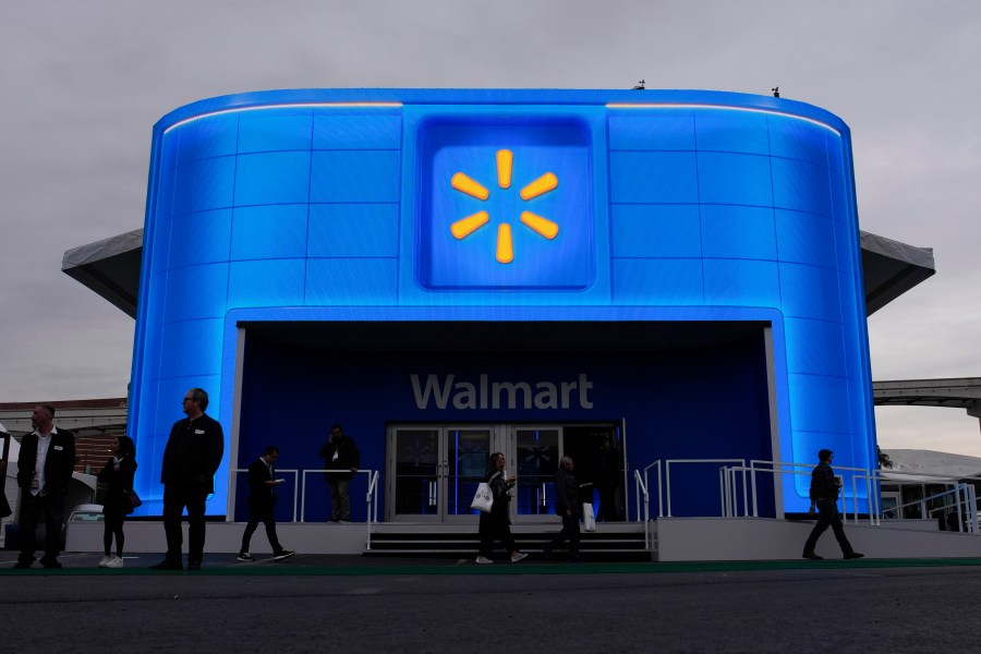 FILE - People walk by the Walmart booth during the CES tech show on Jan. 9, 2024, in Las Vegas. (AP Photo/John Locher, File)