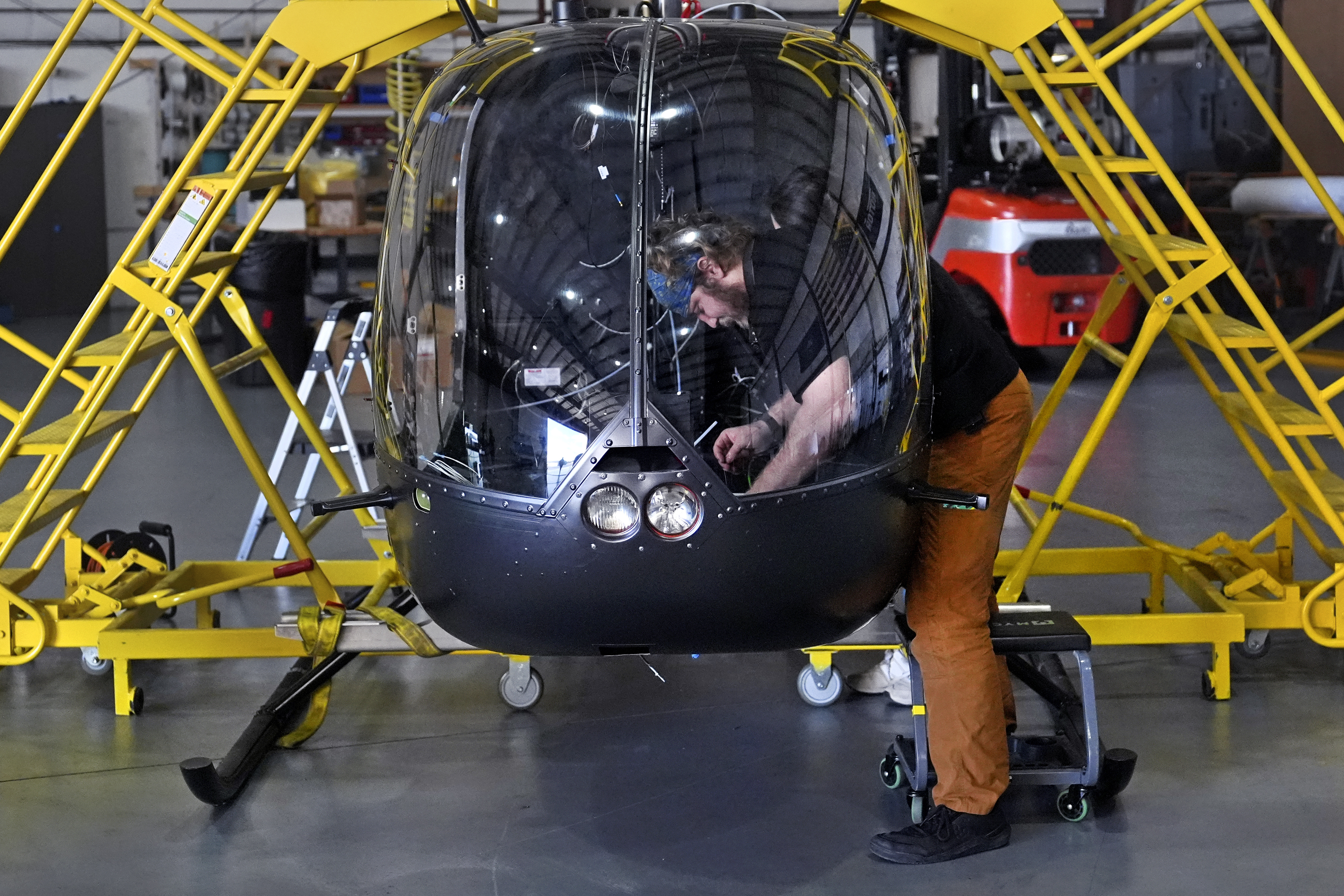 Avionics Technician John Beto installs components into the cockpit of an unmanned semi-autonomous helicopter being built in a hanger at Rotor Technologies , Monday, Nov. 11, 2024, in Nashua, N.H. (AP Photo/Charles Krupa)