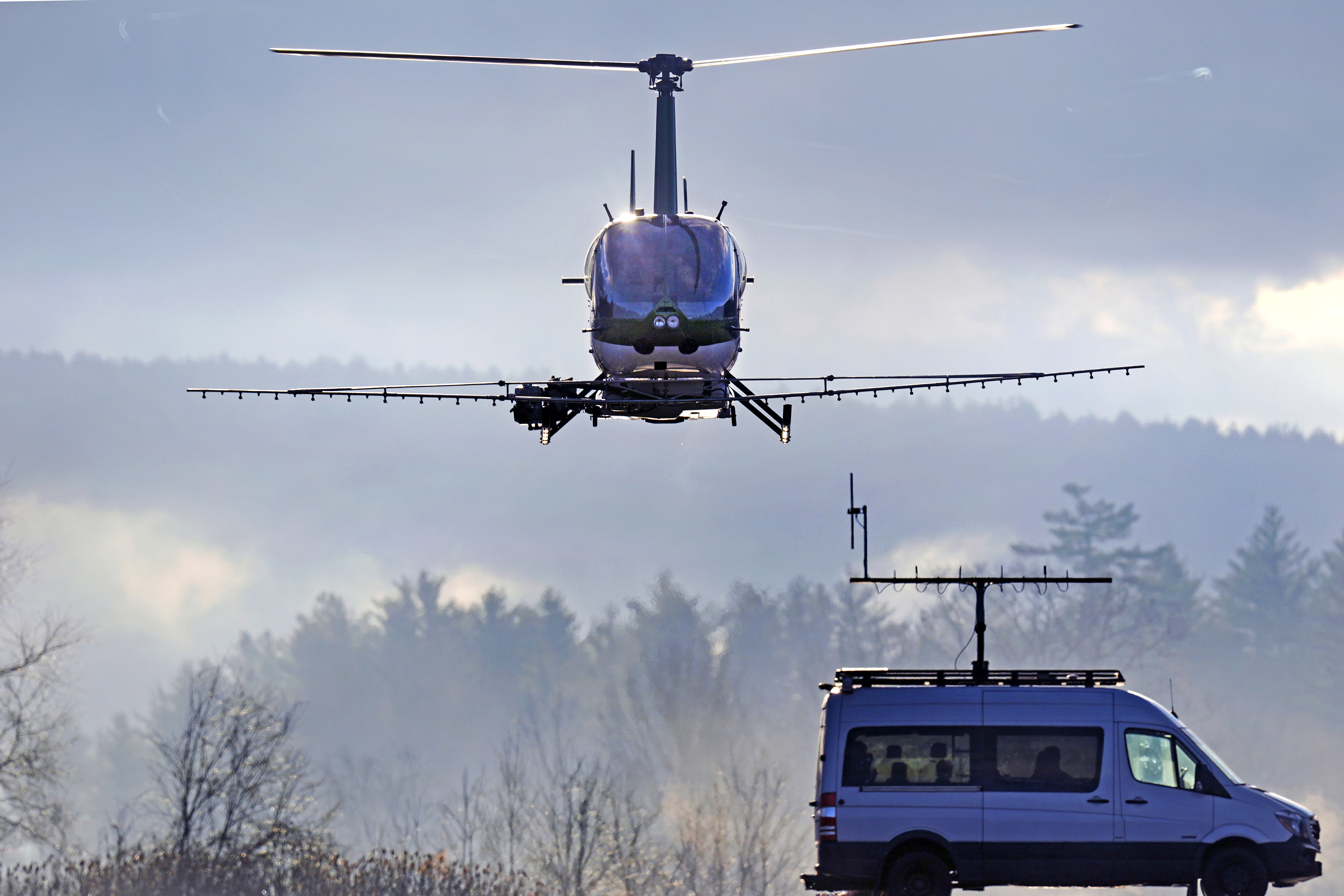 A Rotor Technologies unmanned semi-autonomous helicopter flies away from a van containing a ground control pilot/operator during a test flight over Intervale Airport, Monday, Nov. 11, 2024, in Henniker, N.H. (AP Photo/Charles Krupa)