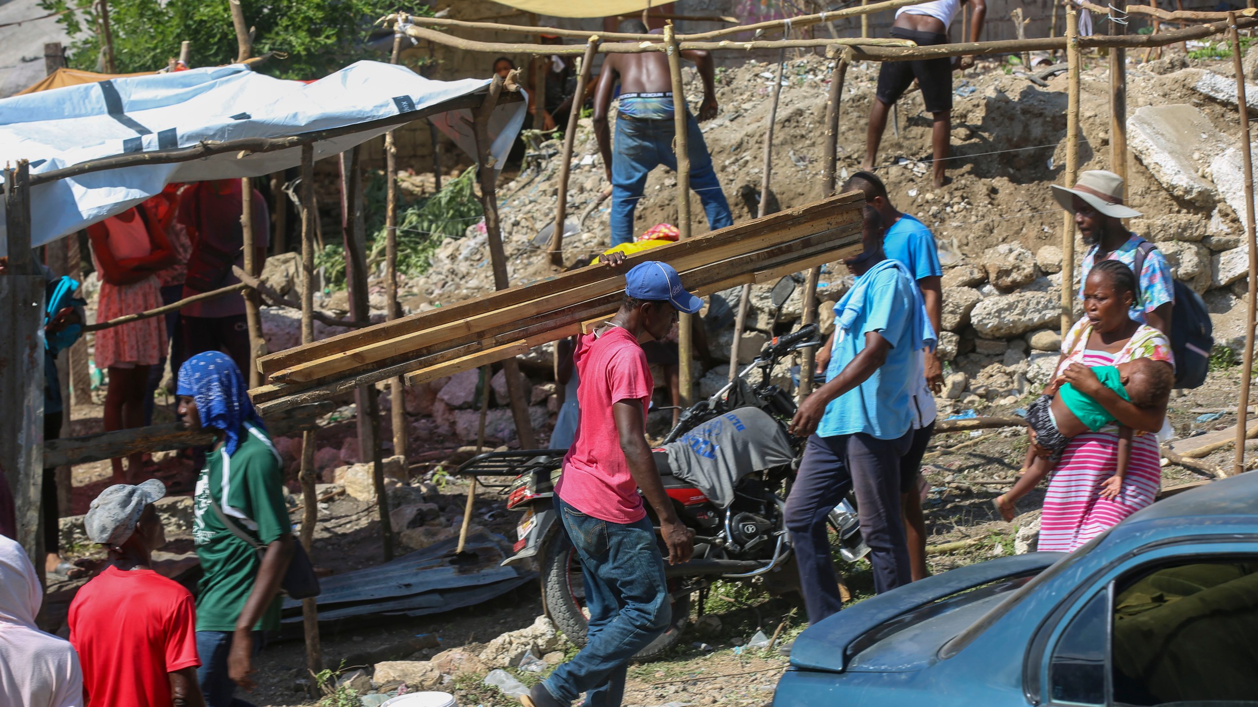 Residents of the Nazon neighborhood displaced by gang violence construct a tent encampment, in Port-au-Prince, Haiti, Friday, Nov. 15, 2024. (AP Photo/Odelyn Joseph)