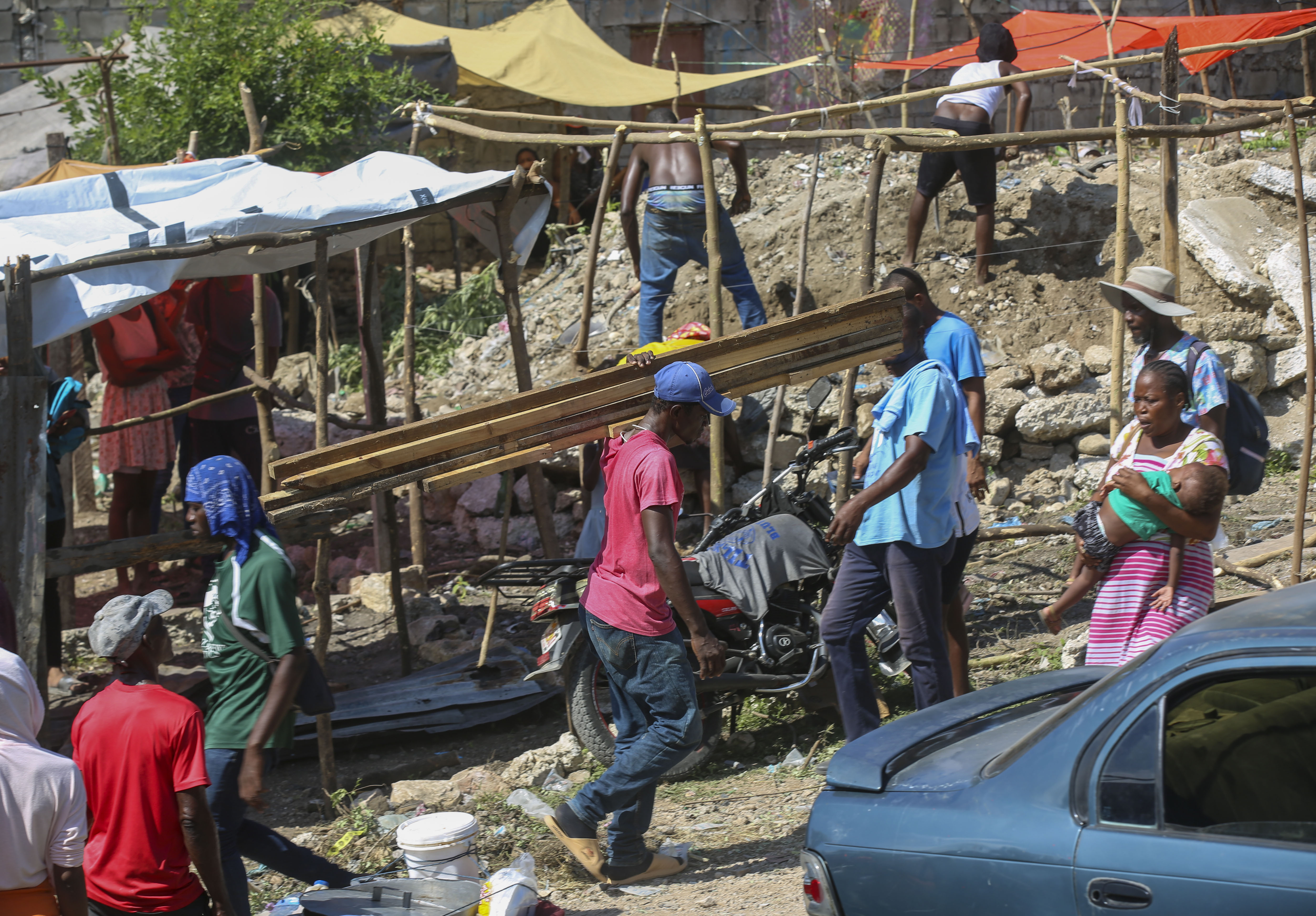 Residents of the Nazon neighborhood displaced by gang violence construct a tent encampment, in Port-au-Prince, Haiti, Friday, Nov. 15, 2024. (AP Photo/Odelyn Joseph)