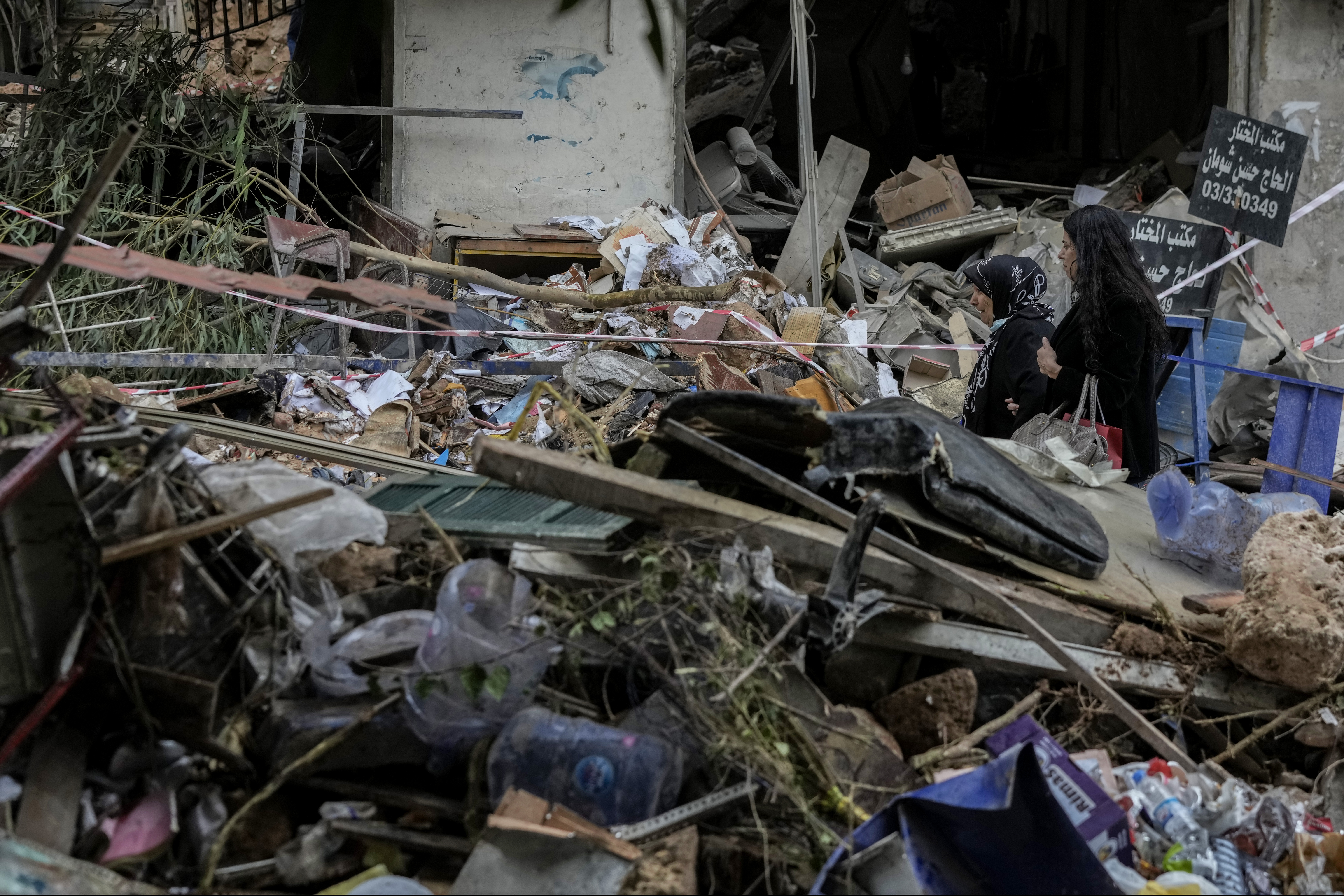 Women react as they pass through debris of a building hit on Monday evening by an Israeli airstrike in central Beirut, Lebanon, Tuesday, Nov. 19, 2024. (AP Photo/Bilal Hussein)