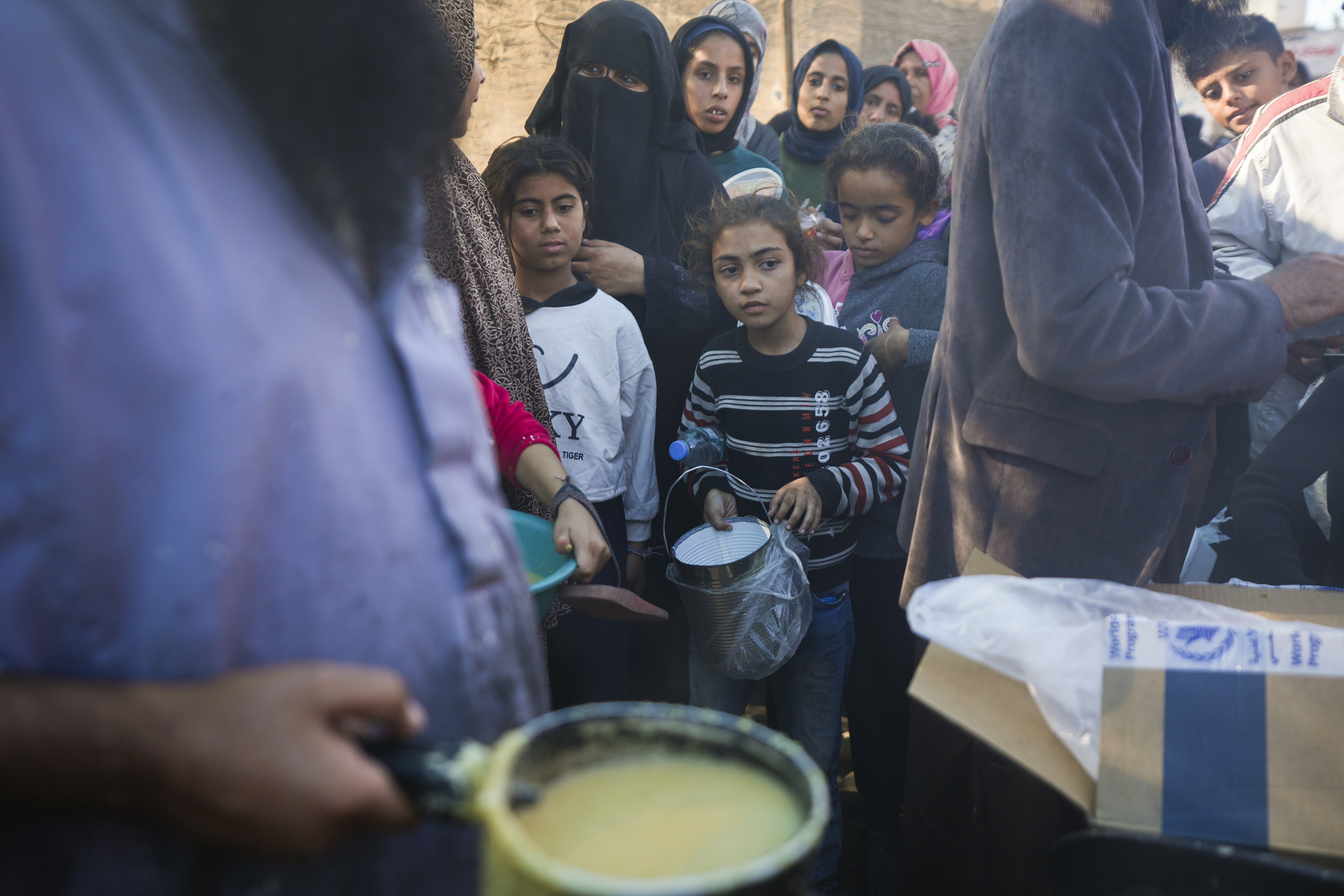 Palestinians queue for food in Deir al-Balah, Gaza Strip, Monday, Nov. 18, 2024. (AP Photo/Abdel Kareem Hana)