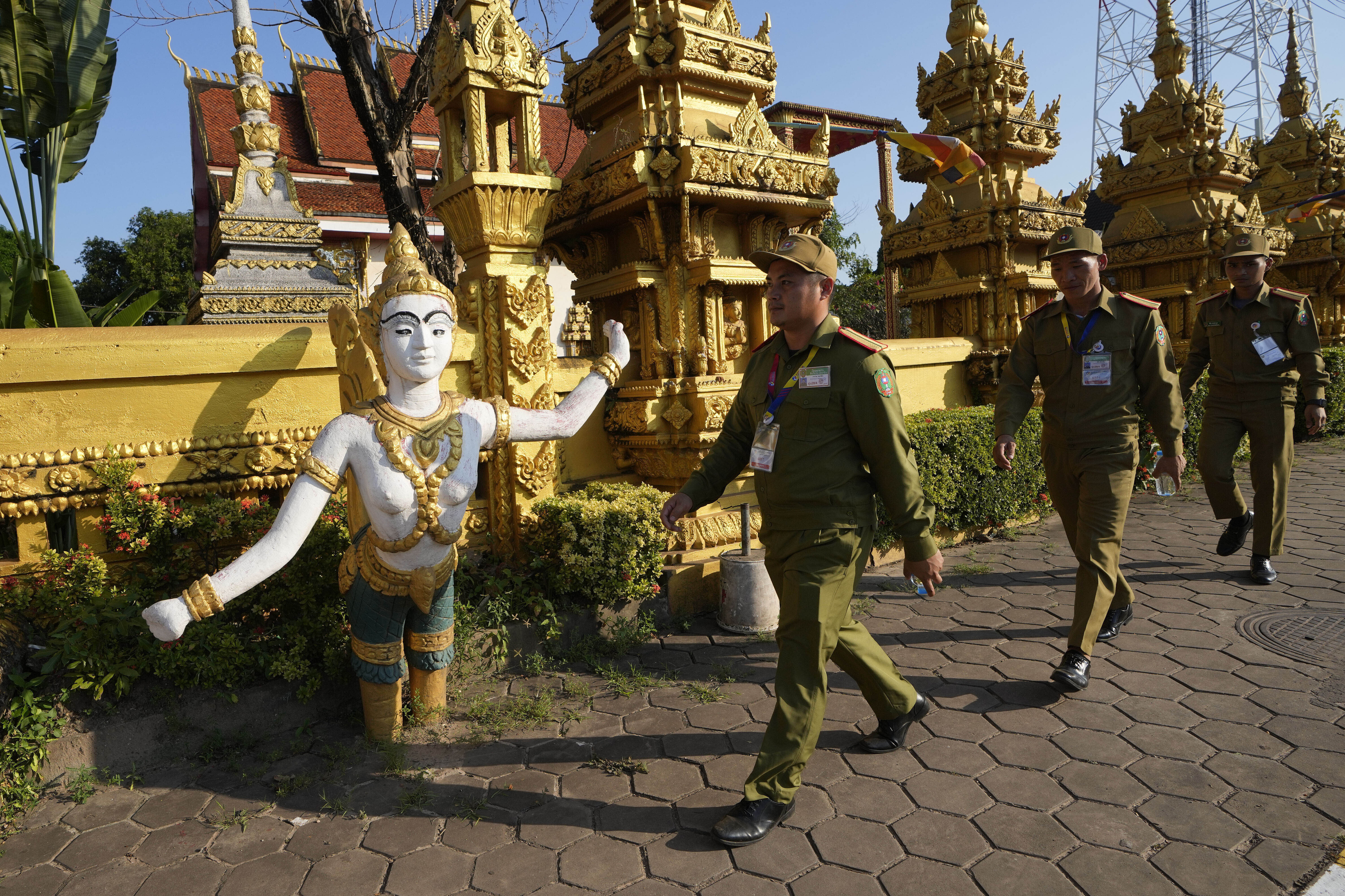 FILE- Laos policemen walk in front of Phon Tha Ya Ram Temple in Vientiane, Laos, Monday, Oct. 7, 2024. (AP Photo/Sakchai Lalit, File)