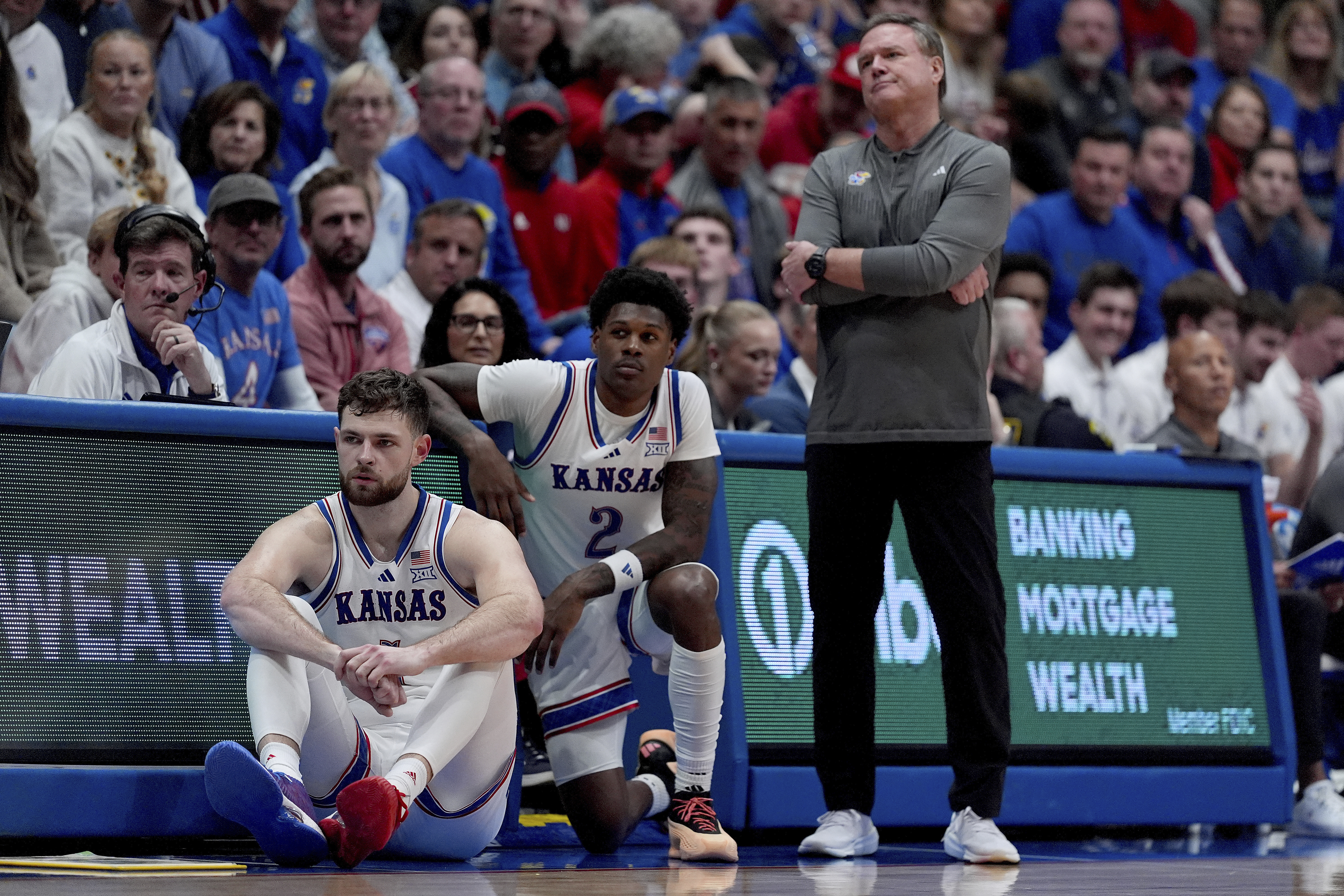 Kansas head coach Bill Self watches with center Hunter Dickinson, left, and guard AJ Storr (2) during the second half of an NCAA college basketball game against UNC Wilmington, Tuesday, Nov. 19, 2024, in Lawrence, Kan. (AP Photo/Charlie Riedel)