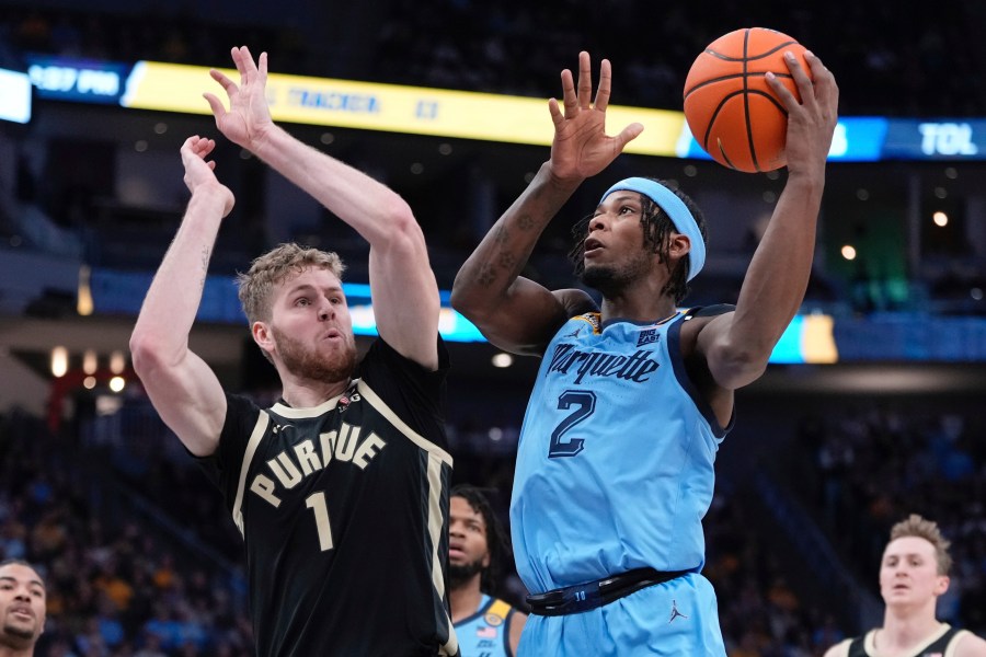 Marquette's Chase Ross shoots past Purdue's Caleb Furst during the first half of an NCAA college basketball game Tuesday, Nov. 19, 2024, in Milwaukee. (AP Photo/Morry Gash)