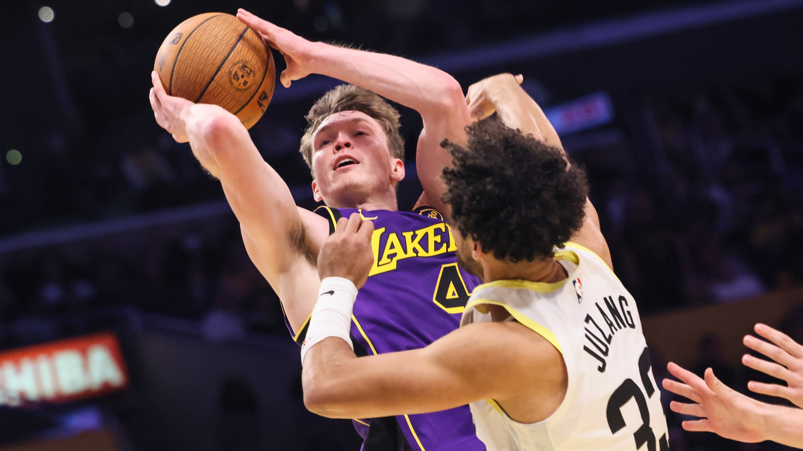 Los Angeles Lakers guard Dalton Knecht, left, attempts to score against Utah Jazz guard Johnny Juzang during the second half of an Emirates NBA Cup basketball game, Tuesday, Nov. 19, 2024, in Los Angeles. (AP Photo/Etienne Laurent)