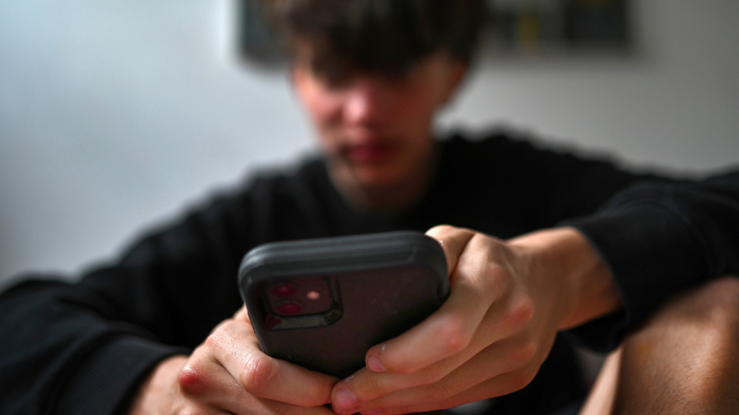 A teenager uses his mobile phone to access social media, Sydney, Wednesday, Nov. 13, 2024. (Dean Lewins/AAP Image VIA AP)