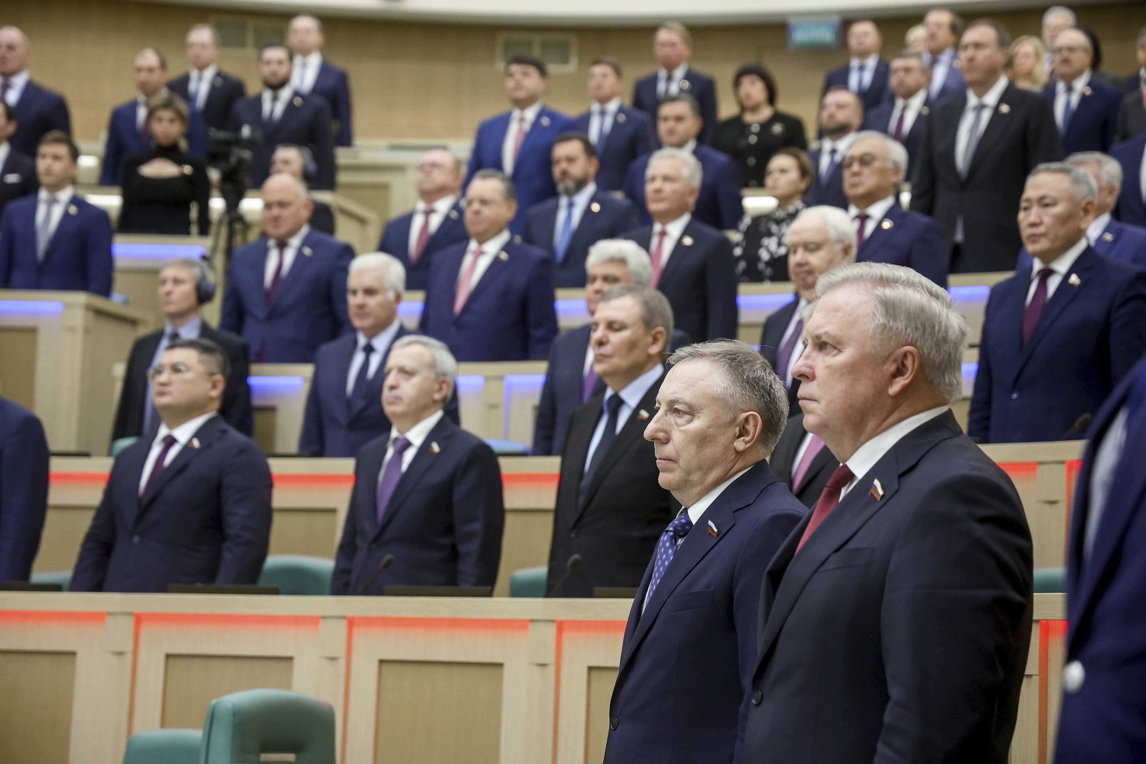 In this photo released by the Federation Council of The Federal Assembly of the Russian Federation Press Service, lawmakers of Federation Council of the Federal Assembly of the Russian Federation listen to the national anthem prior to a session in Moscow, Wednesday, Nov. 20, 2024. (The Federation Council of The Federal Assembly of The Russian Federation Press Service via AP)