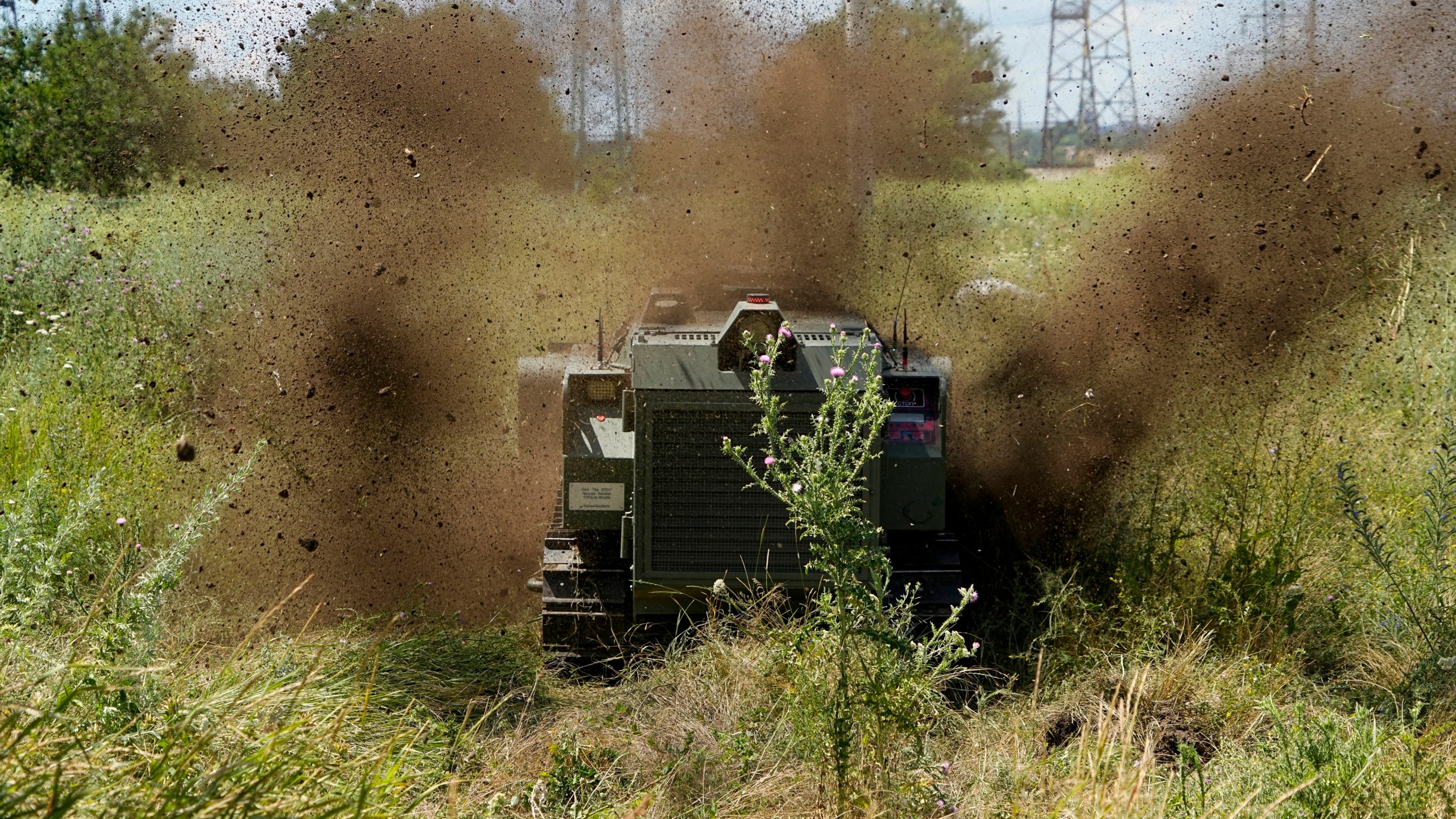 FILE - A Russian military robotic vehicle detonates a land mine on a mine clearing mission to defuse mines along the high voltage line in Mariupol, on the territory which is under the Government of the Donetsk People's Republic control, eastern Ukraine, July 13, 2022. This photo was taken during a trip organized by the Russian Ministry of Defense. (AP Photo, File)