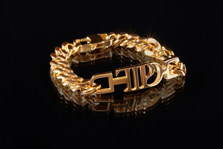 This image shows a gold-plated chain link bracelet, featuring the logo for Taylor Swift's album, "The Tortured Poets Department." (TAS Rights Management via AP)