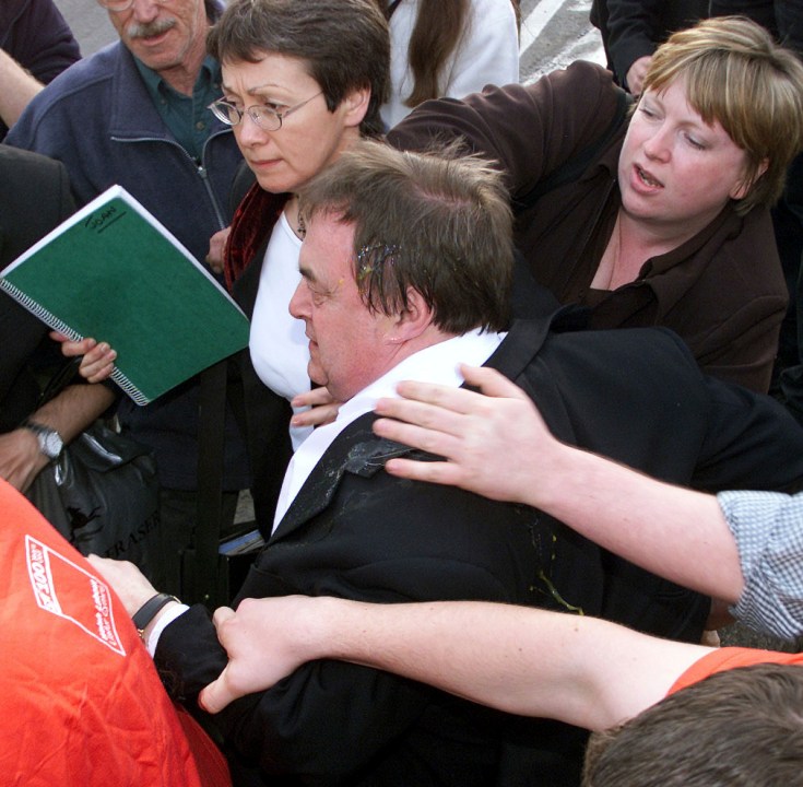 FILE -Britain's deputy prime minister John Prescott, covered in egg and ruffed up, being separated from his attacker, in the North Wales seaside resort of Rhyl where he was to address a Labour Party rally, May, 16, 2001.(David Kendall/PA via AP, File)