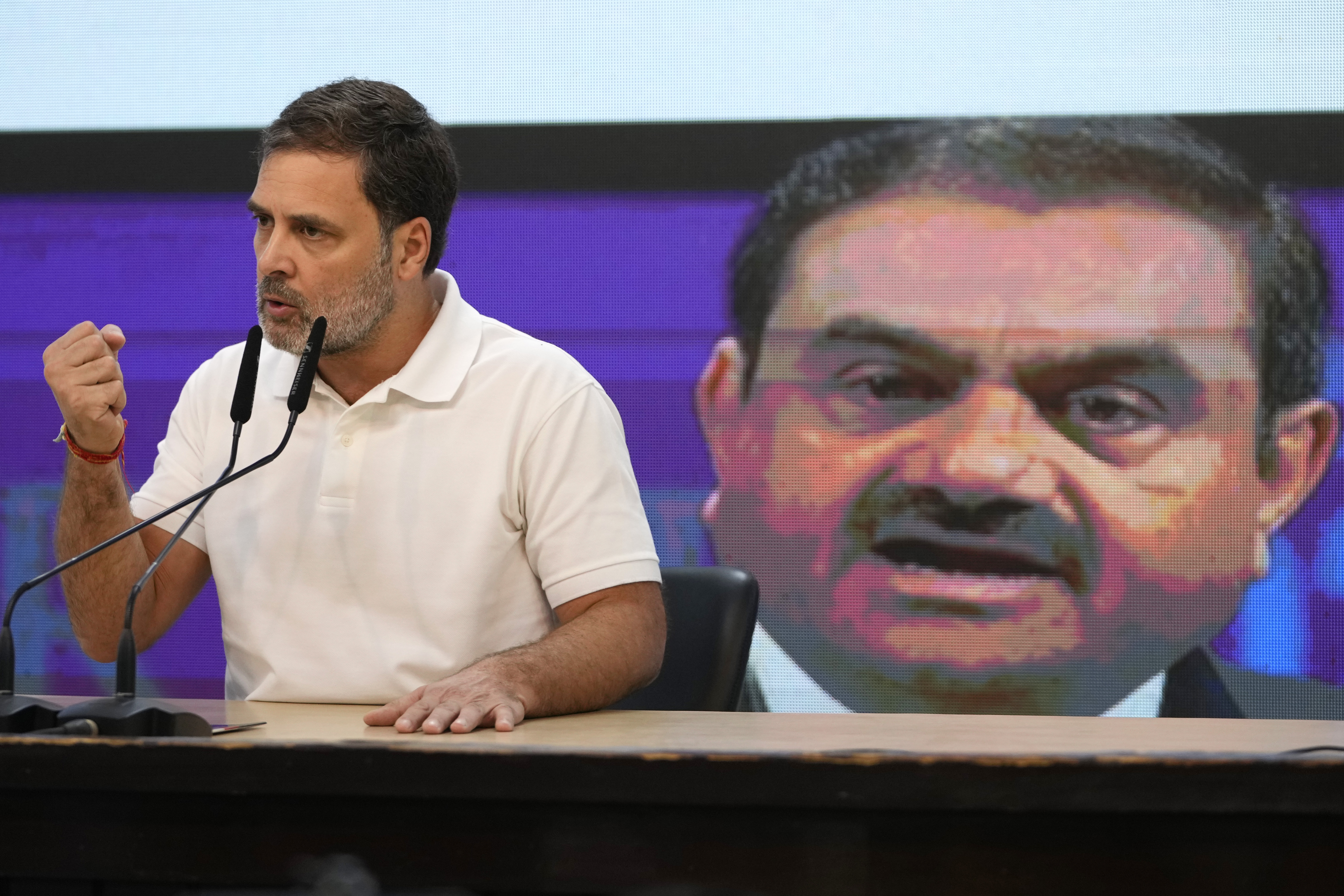 India's opposition Congress party leader Rahul Gandhi addresses the media on Indian businessman Gautam Adani, after Adani was indicted by U.S. prosecutors on charges he duped investors in a massive solar energy project in India, in New Delhi, India, Thursday, Nov. 21, 2024. Image behind shows Adani. (AP Photo/Manish Swarup)