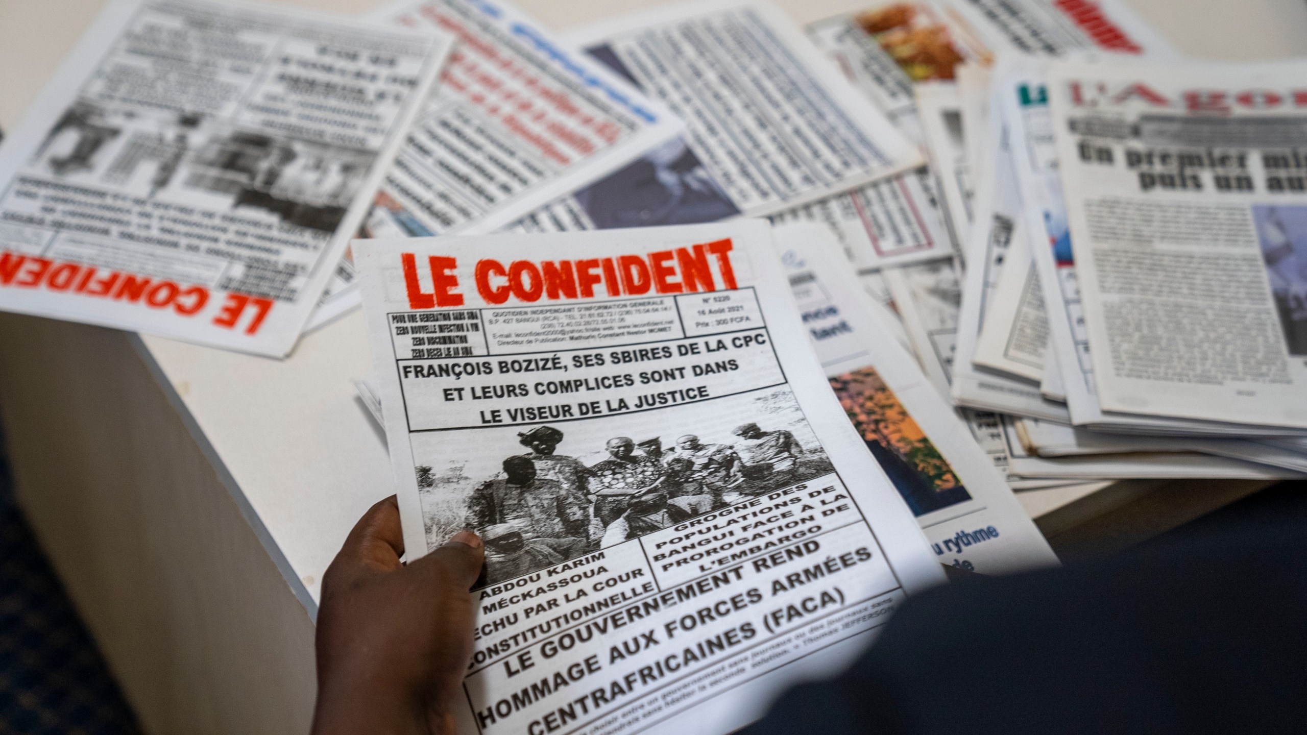 Whistleblower Ephrem Yaline-Ngonzo, who was recruited by Kremlin-backed Wagner forces to spread Russian propaganda in Central African Republic, sorts through CAR newspapers during a visit in Johannesburg, South Africa, Nov. 2, 2022. (Forbidden Stories via AP)