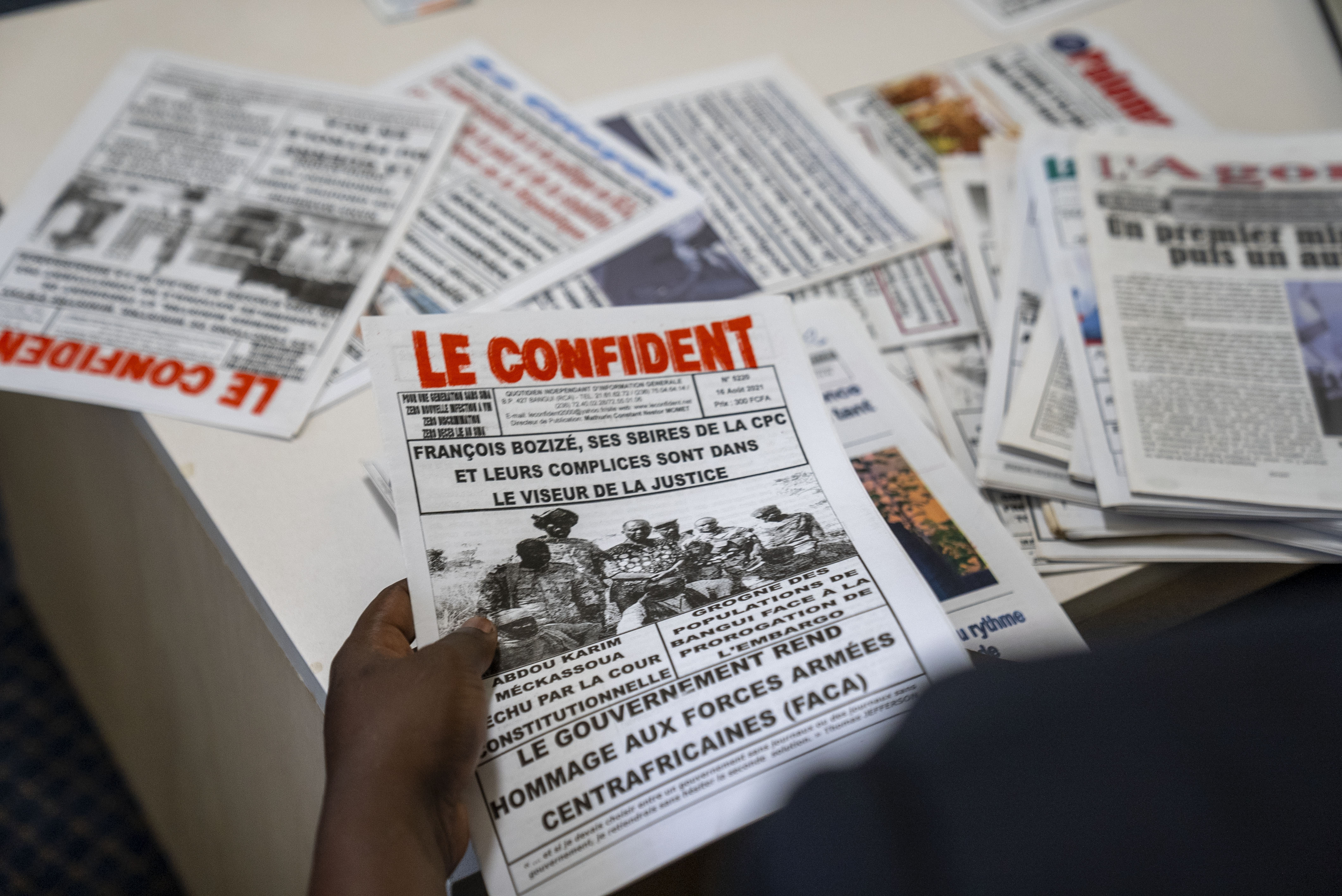 Whistleblower Ephrem Yaline-Ngonzo, who was recruited by Kremlin-backed Wagner forces to spread Russian propaganda in Central African Republic, sorts through CAR newspapers during a visit in Johannesburg, South Africa, Nov. 2, 2022. (Forbidden Stories via AP)