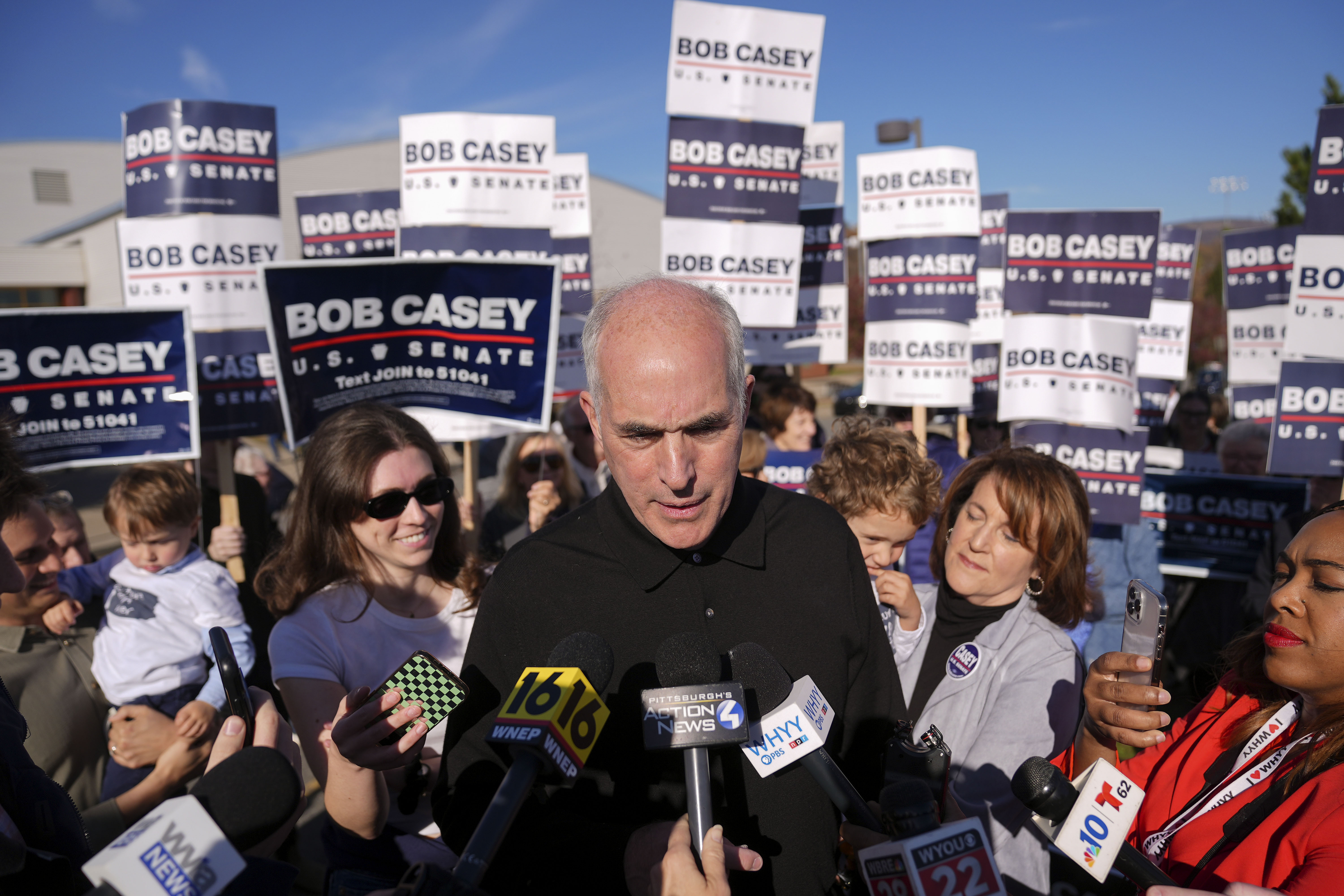 Sen. Bob Casey, D-Pa., left, stops to speak to members of the media before voting, Tuesday, Nov. 5, 2024, in Scranton, Pa. (AP Photo/Matt Rourke)