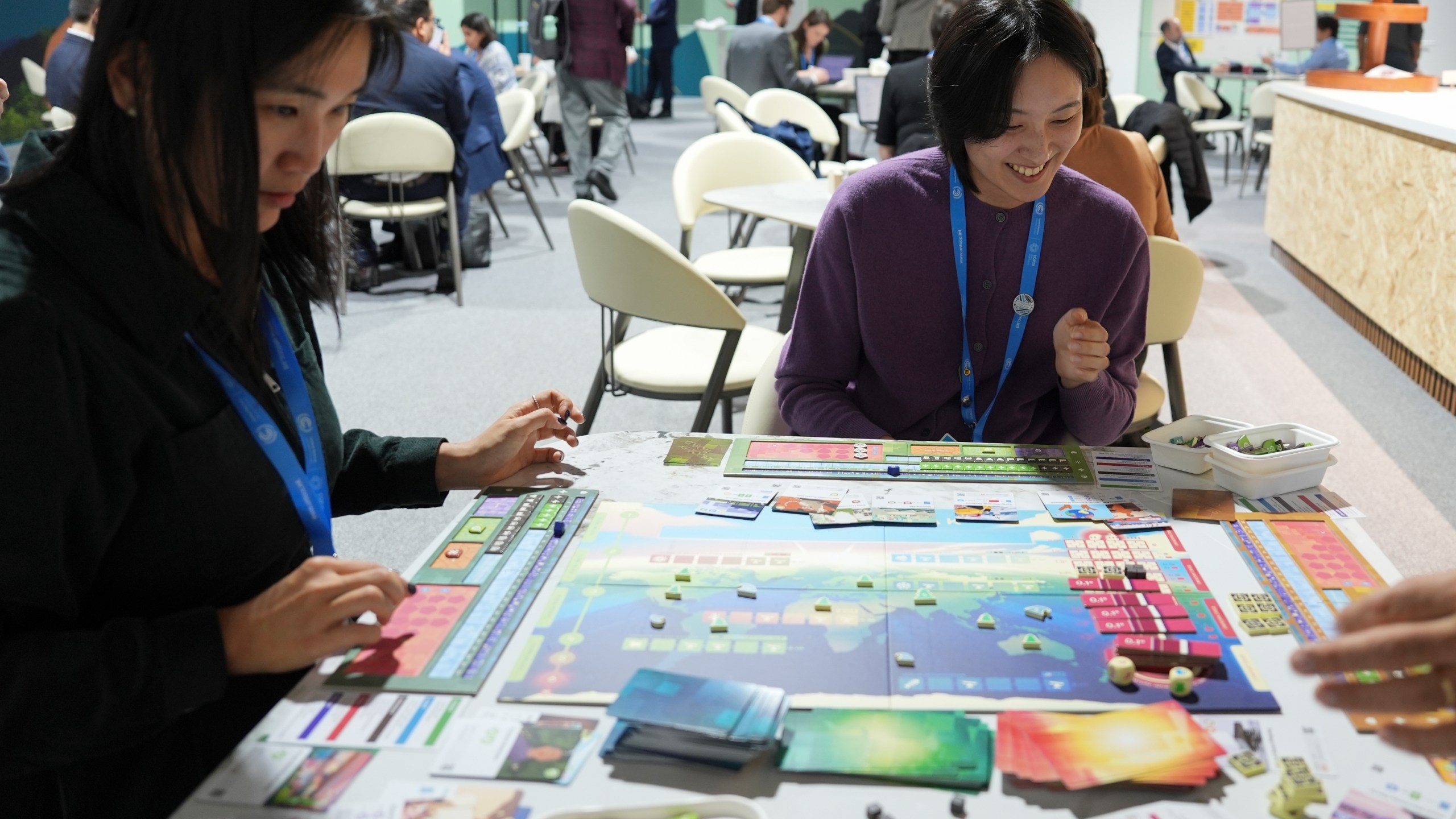 Borami Seo, Solutions for Our Climate, left, and Yi Hyun Kim, Solutions for Our Climate, play Daybreak, a game where players are supposed to work together to find a way to curb climate change, at the COP29 U.N. Climate Summit, Tuesday, Nov. 19, 2024, in Baku, Azerbaijan. (AP Photo/Joshua A. Bickel)