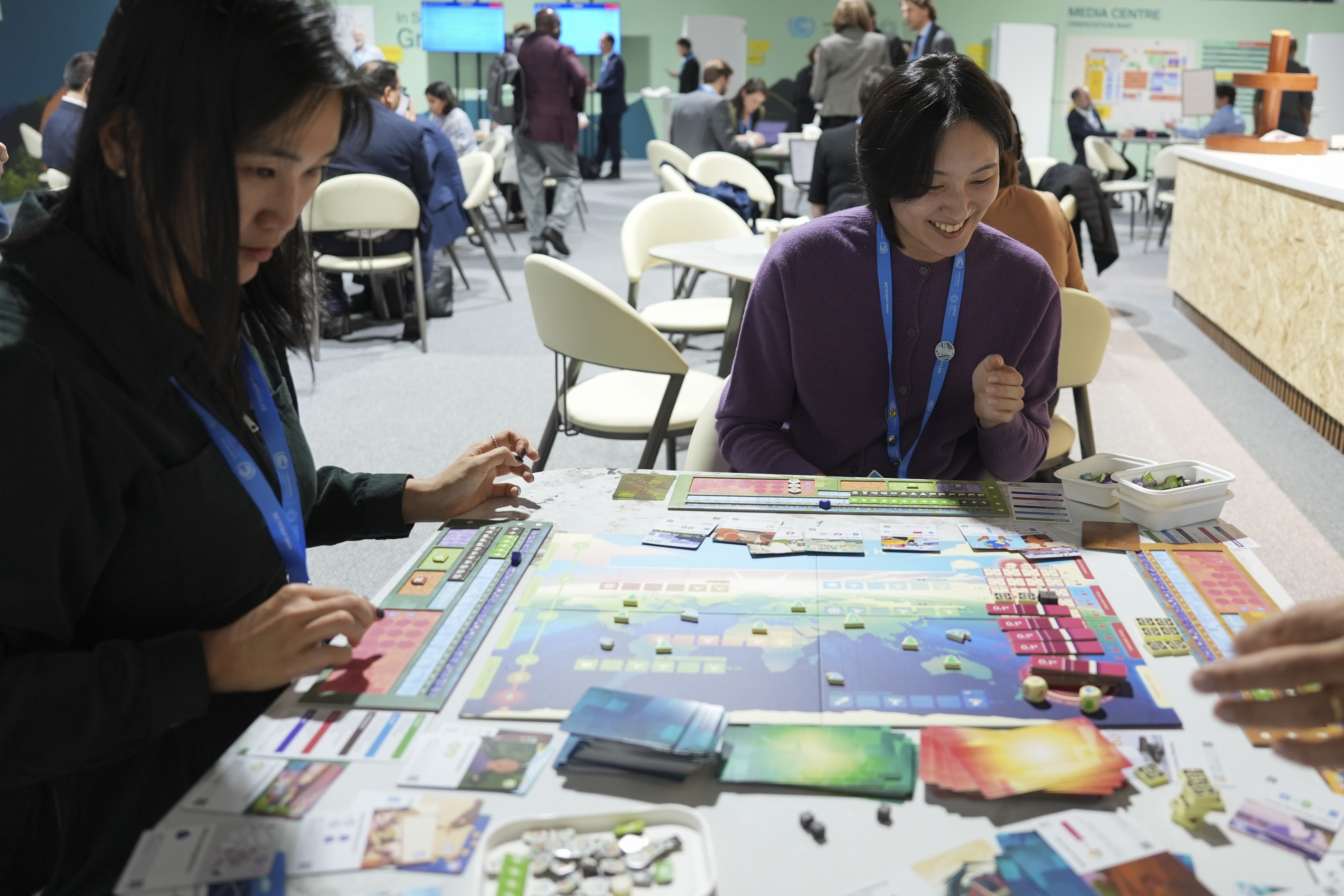 Borami Seo, Solutions for Our Climate, left, and Yi Hyun Kim, Solutions for Our Climate, play Daybreak, a game where players are supposed to work together to find a way to curb climate change, at the COP29 U.N. Climate Summit, Tuesday, Nov. 19, 2024, in Baku, Azerbaijan. (AP Photo/Joshua A. Bickel)