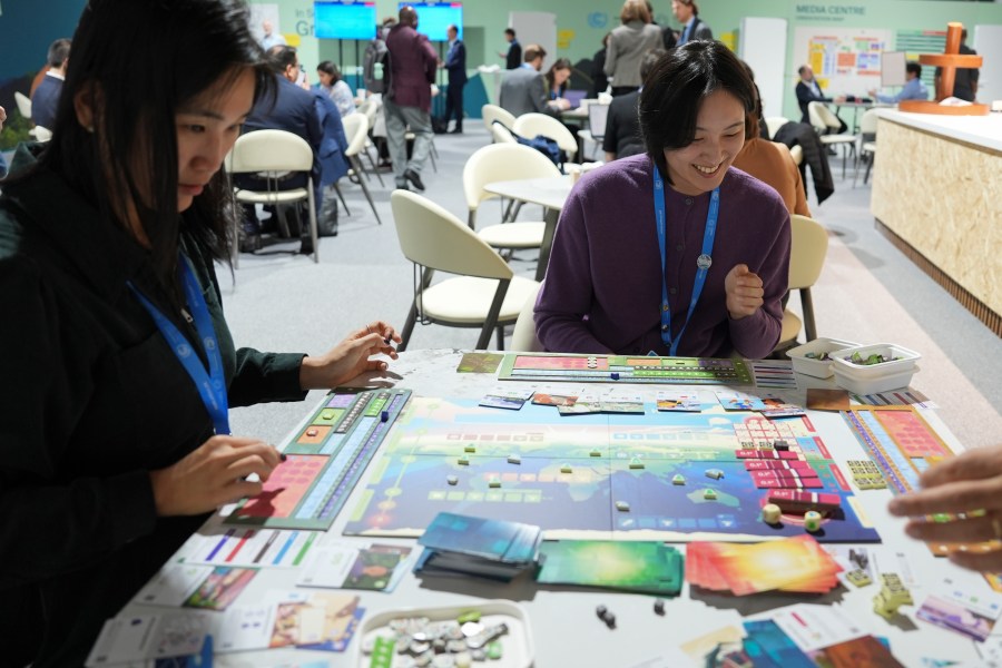 Borami Seo, Solutions for Our Climate, left, and Yi Hyun Kim, Solutions for Our Climate, play Daybreak, a game where players are supposed to work together to find a way to curb climate change, at the COP29 U.N. Climate Summit, Tuesday, Nov. 19, 2024, in Baku, Azerbaijan. (AP Photo/Joshua A. Bickel)