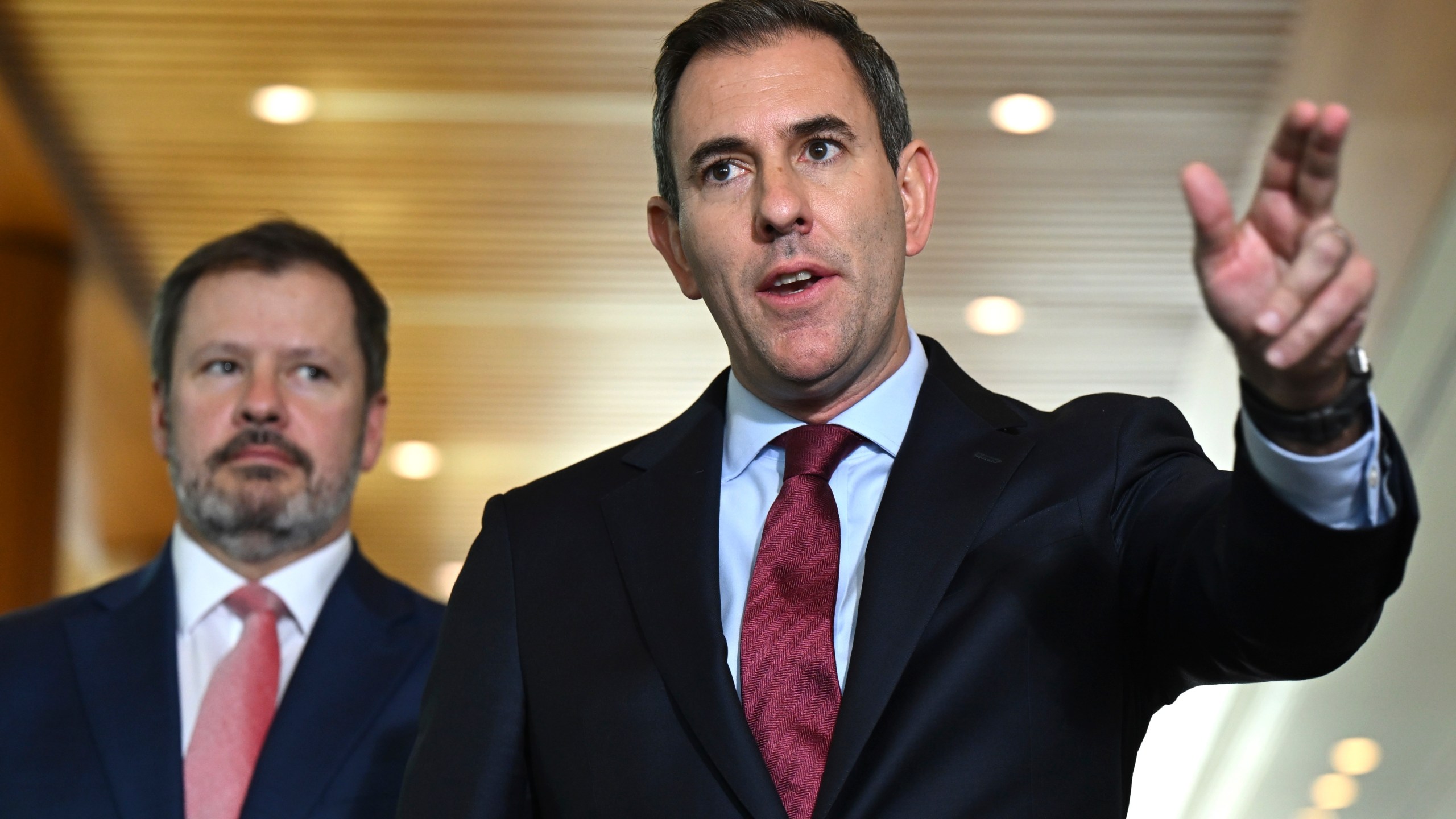 Australian Treasurer Jim Chalmers, right, gestures as he and Industry Minister Ed Husic speak to the media during a press conference at Parliament House in Canberra, Friday, Nov. 22, 2024. (Lukas Coch/AAP Image via AP)