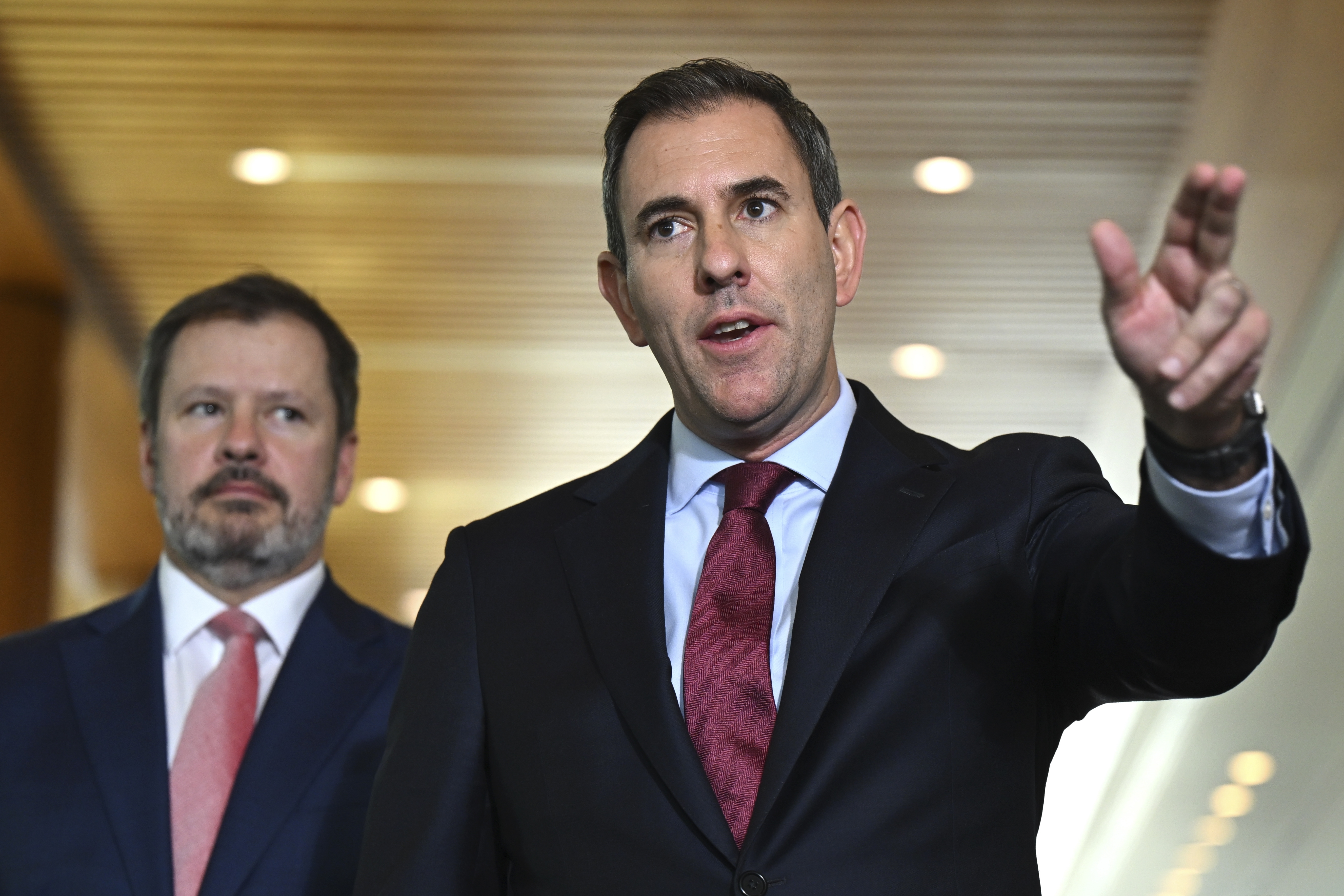 Australian Treasurer Jim Chalmers, right, gestures as he and Industry Minister Ed Husic speak to the media during a press conference at Parliament House in Canberra, Friday, Nov. 22, 2024. (Lukas Coch/AAP Image via AP)