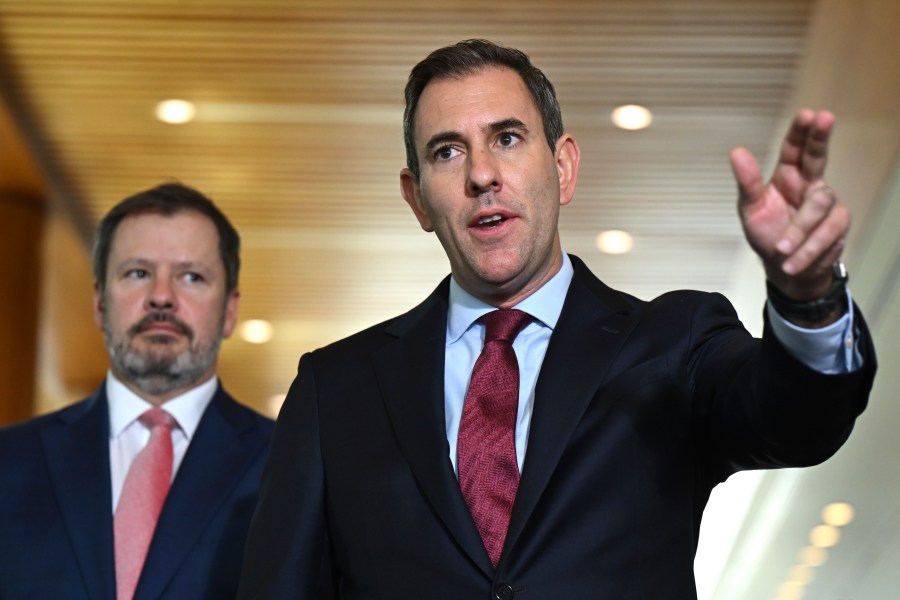 Australian Treasurer Jim Chalmers, right, gestures as he and Industry Minister Ed Husic speak to the media during a press conference at Parliament House in Canberra, Friday, Nov. 22, 2024. (Lukas Coch/AAP Image via AP)