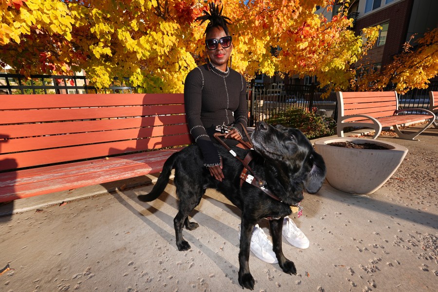 Amber Sherrard and her 10-year-old black Labrador Della are shown outside their home Friday, Nov. 15, 2024, in east Denver. (AP Photo/David Zalubowski)