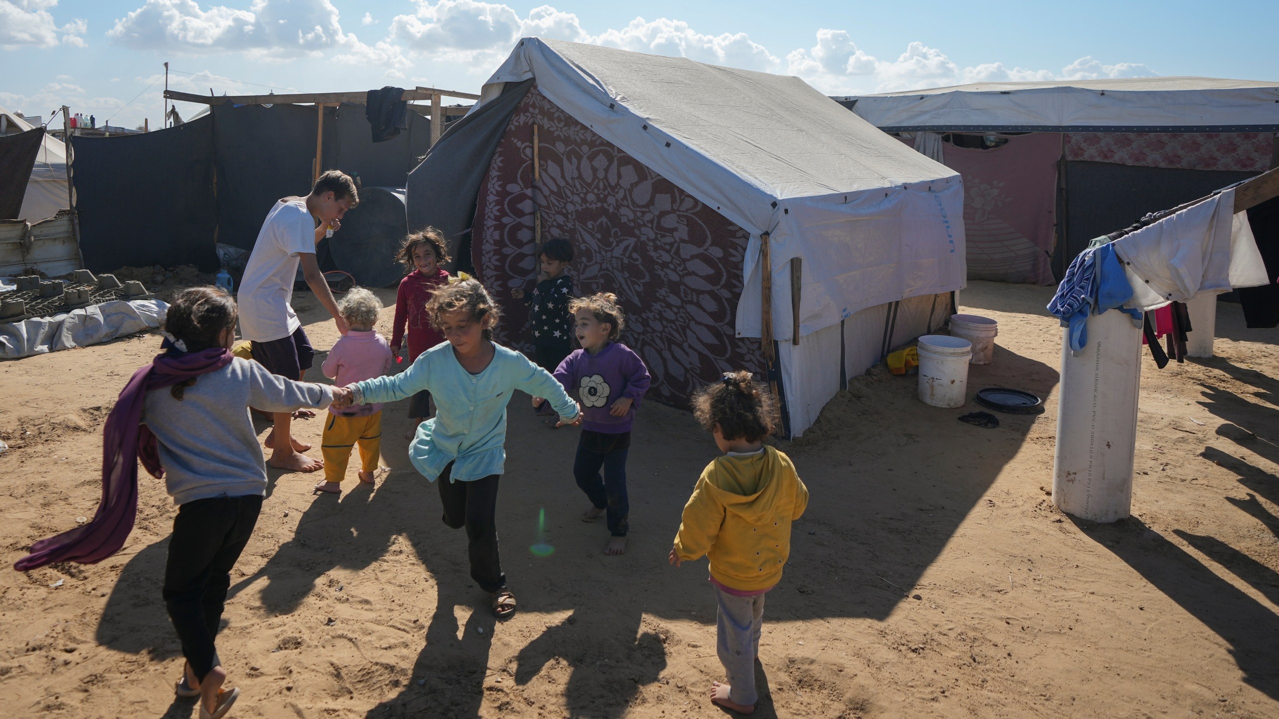 Children play next to their tent in a refugee camp in Deir al-Balah, Gaza Strip, Tuesday Nov. 19, 2024. (AP Photo/Abdel Kareem Hana)