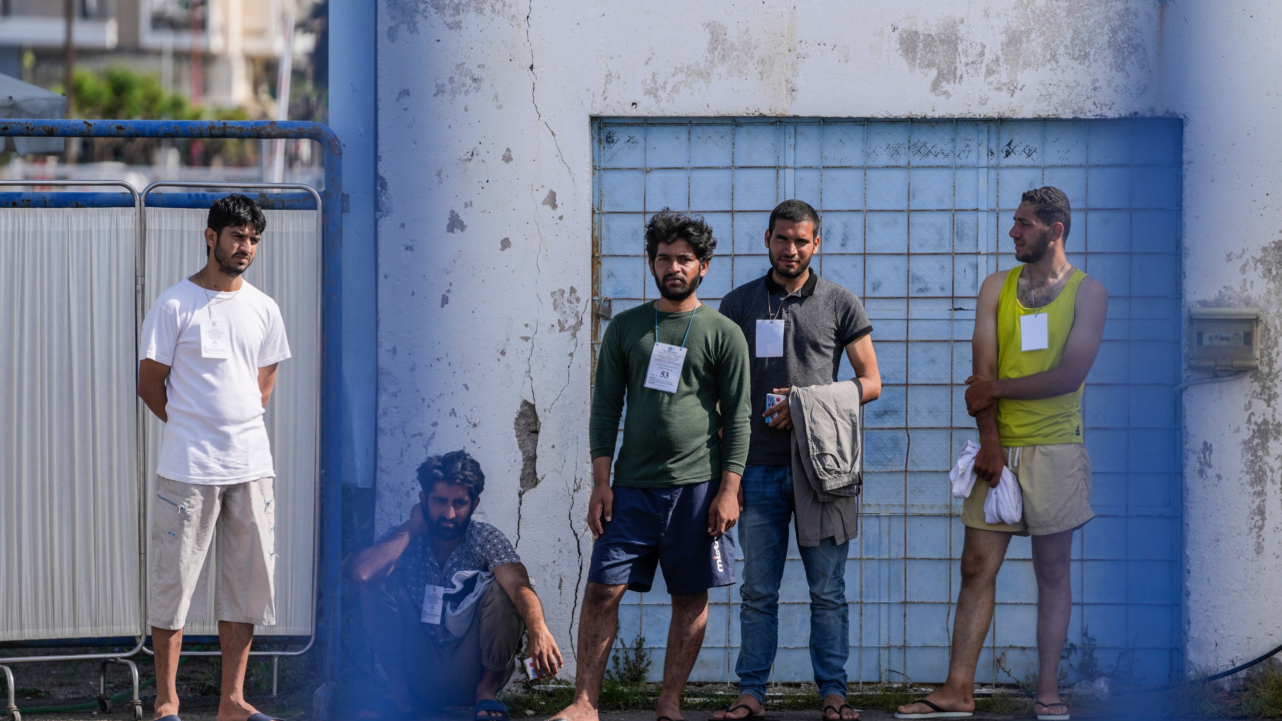 FILE - Survivors of a migrant shipwreck stand outside a warehouse at the port in Kalamata town, southwest of Athens, Greece, on June 15, 2023. (AP Photo/Thanassis Stavrakis, File)