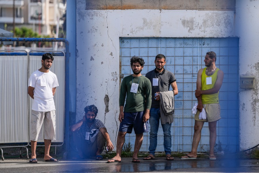 FILE - Survivors of a migrant shipwreck stand outside a warehouse at the port in Kalamata town, southwest of Athens, Greece, on June 15, 2023. (AP Photo/Thanassis Stavrakis, File)