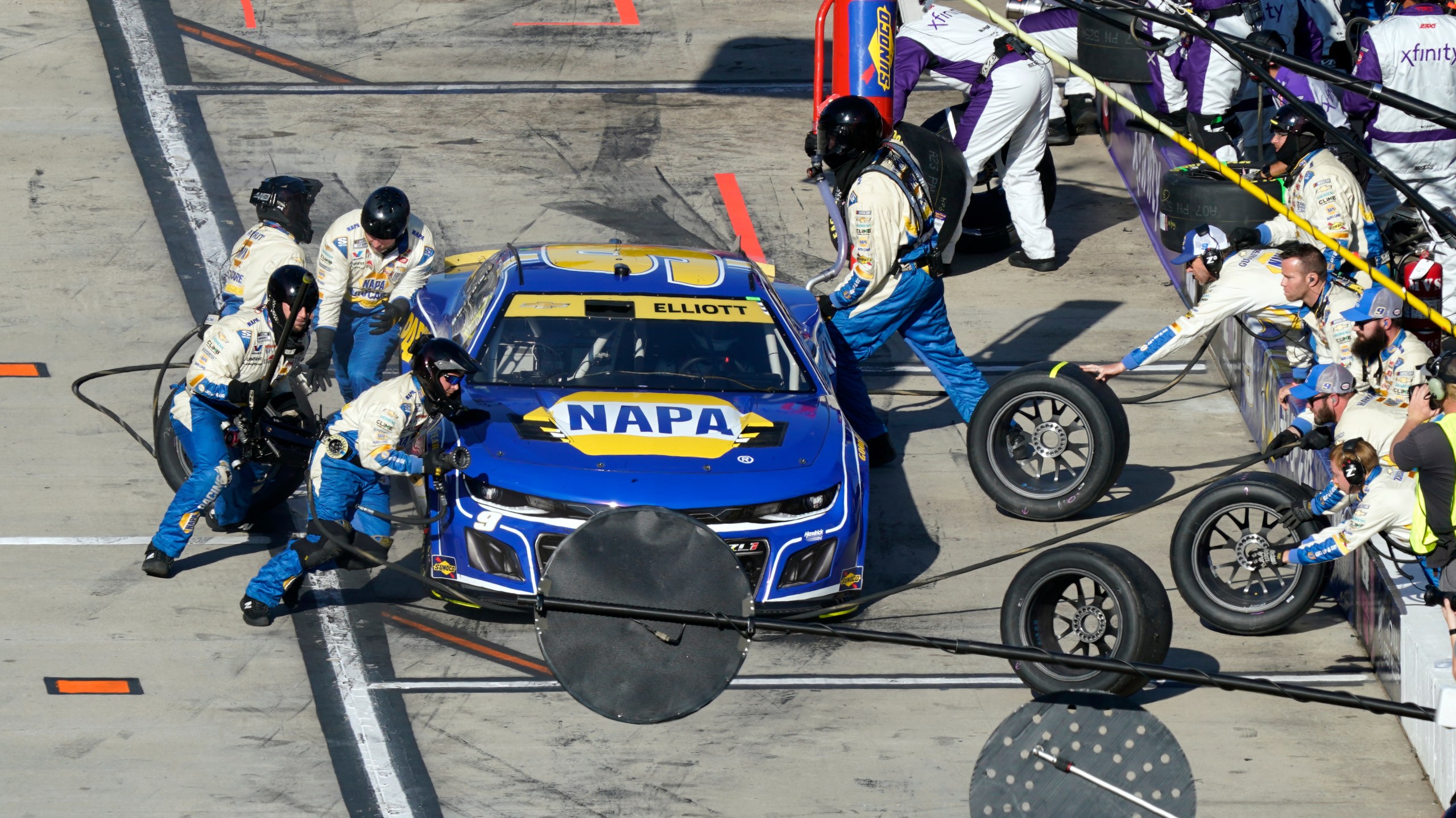 Crew members perform a pit stop on driver Chase Elliott's car during a NASCAR Cup Series auto race at Martinsville Speedway in Martinsville, Va., Sunday, Nov. 3, 2024. (AP Photo/Chuck Burton)