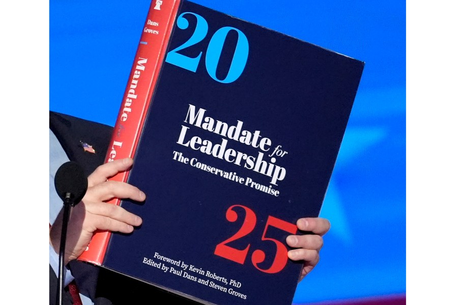 FILE - A copy of Project 2025 is held during the Democratic National Convention, Aug. 21, 2024, in Chicago. (AP Photo/J. Scott Applewhite, File)