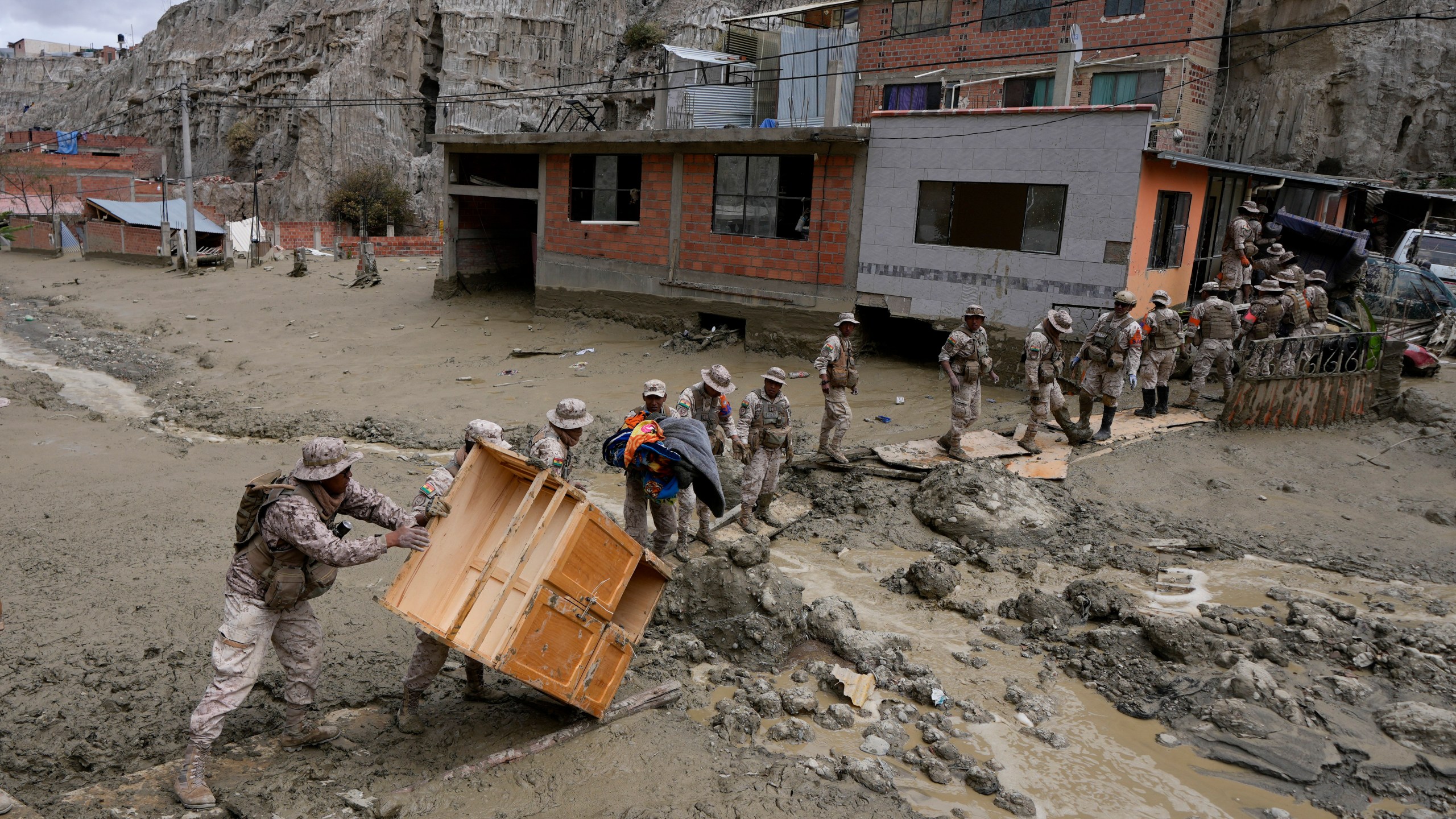 Soldiers recover a piece of furniture from a home flooded by a landslide caused by heavy rains in La Paz, Bolivia, Sunday, Nov. 24, 2024. (AP Photo/Juan Karita)