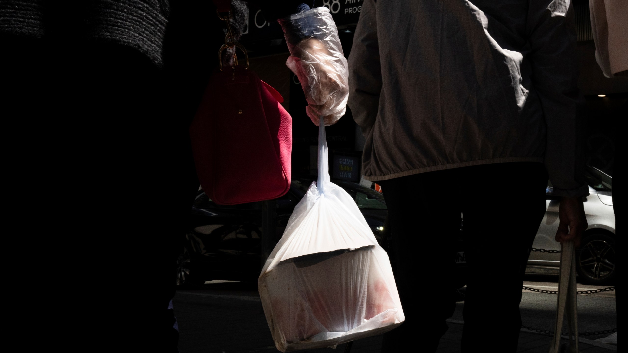 FILE - A pedestrian carries takeaway food in a plastic bag in Hong Kong, March 13, 2024.(AP Photo/Louise Delmotte, File)