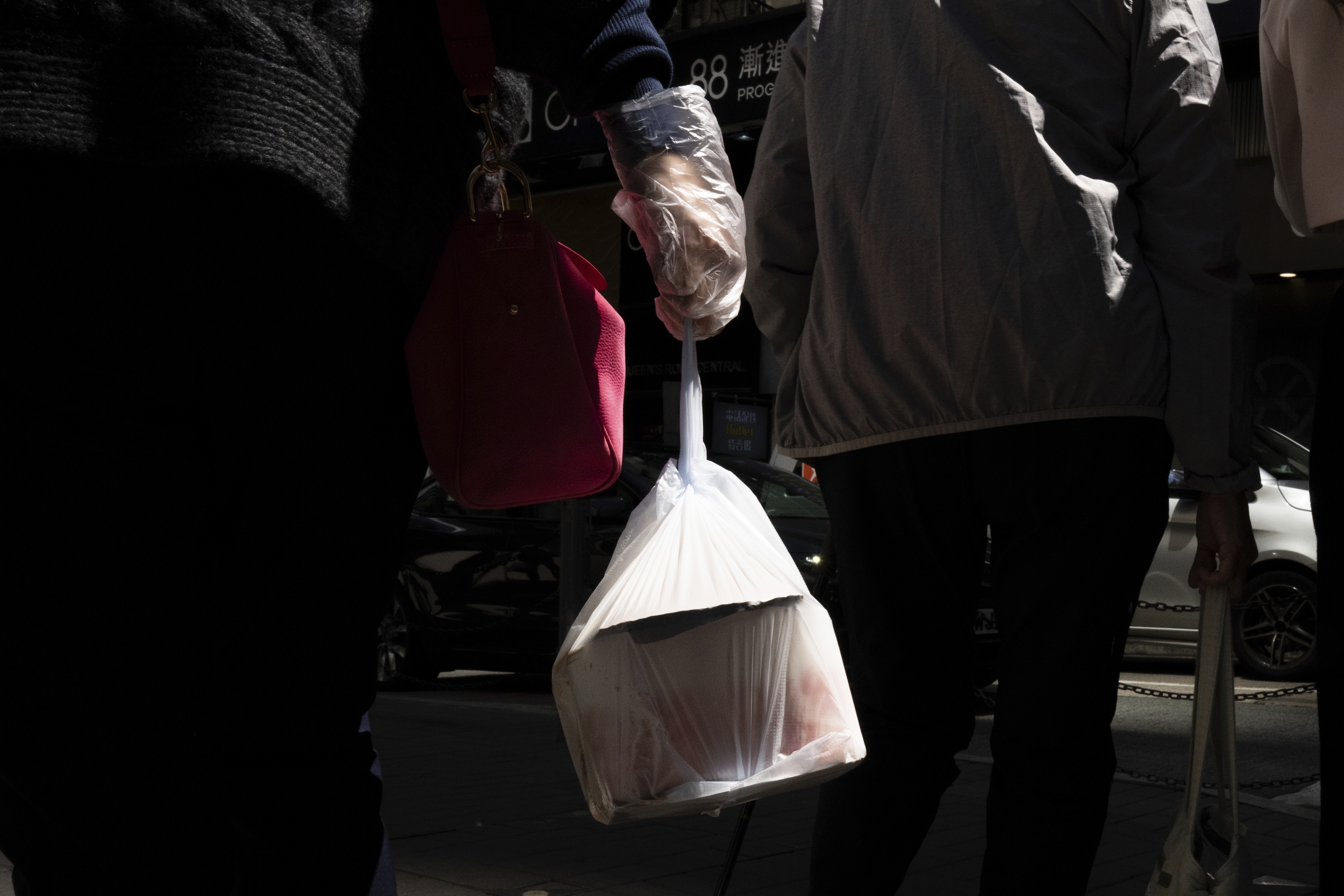 FILE - A pedestrian carries takeaway food in a plastic bag in Hong Kong, March 13, 2024.(AP Photo/Louise Delmotte, File)