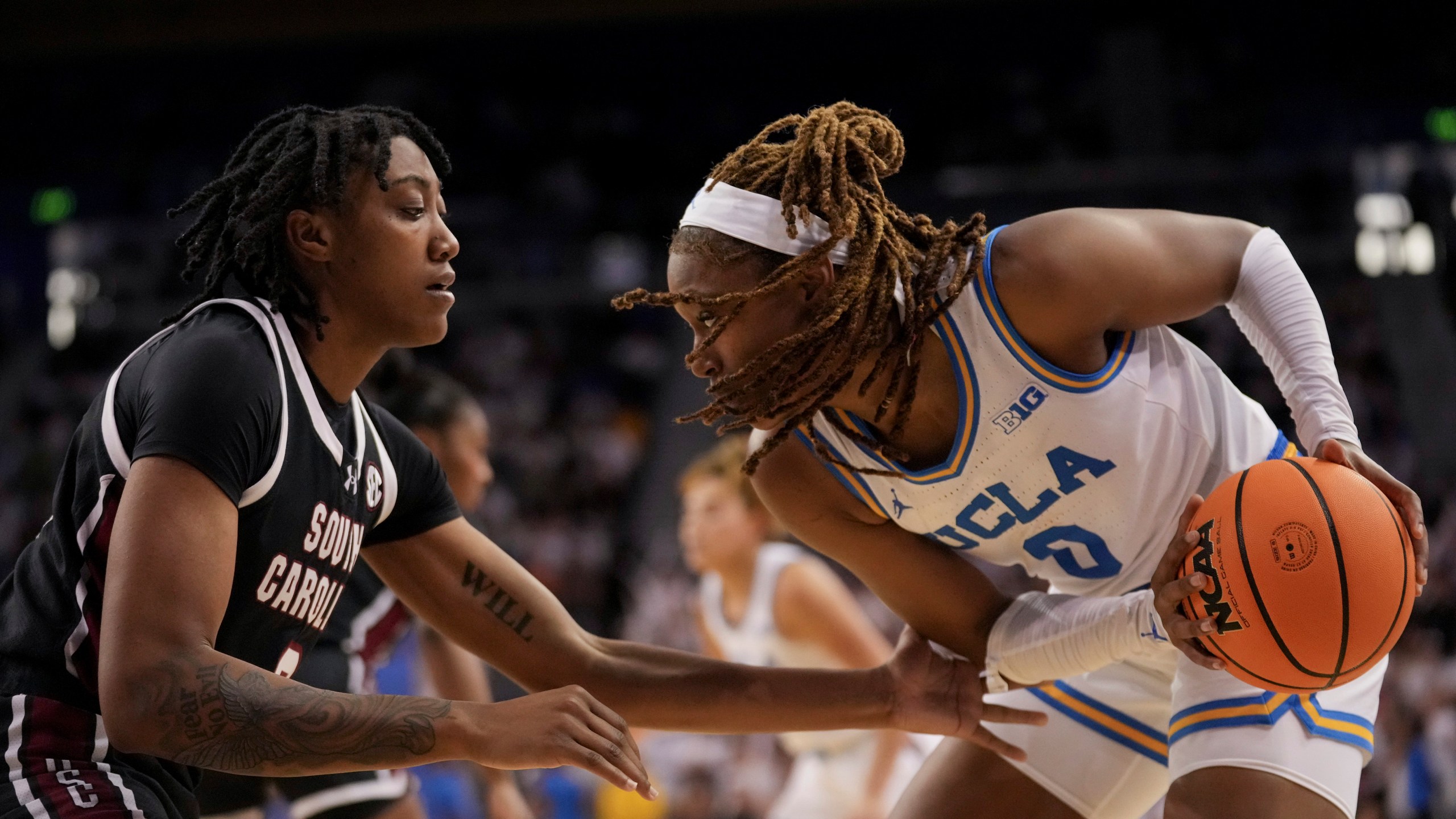 UCLA forward Janiah Barker (0) drives against South Carolina forward Ashlyn Watkins during the second half of an NCAA college basketball game, Sunday, Nov. 24, 2024, in Los Angeles. (AP Photo/Eric Thayer)