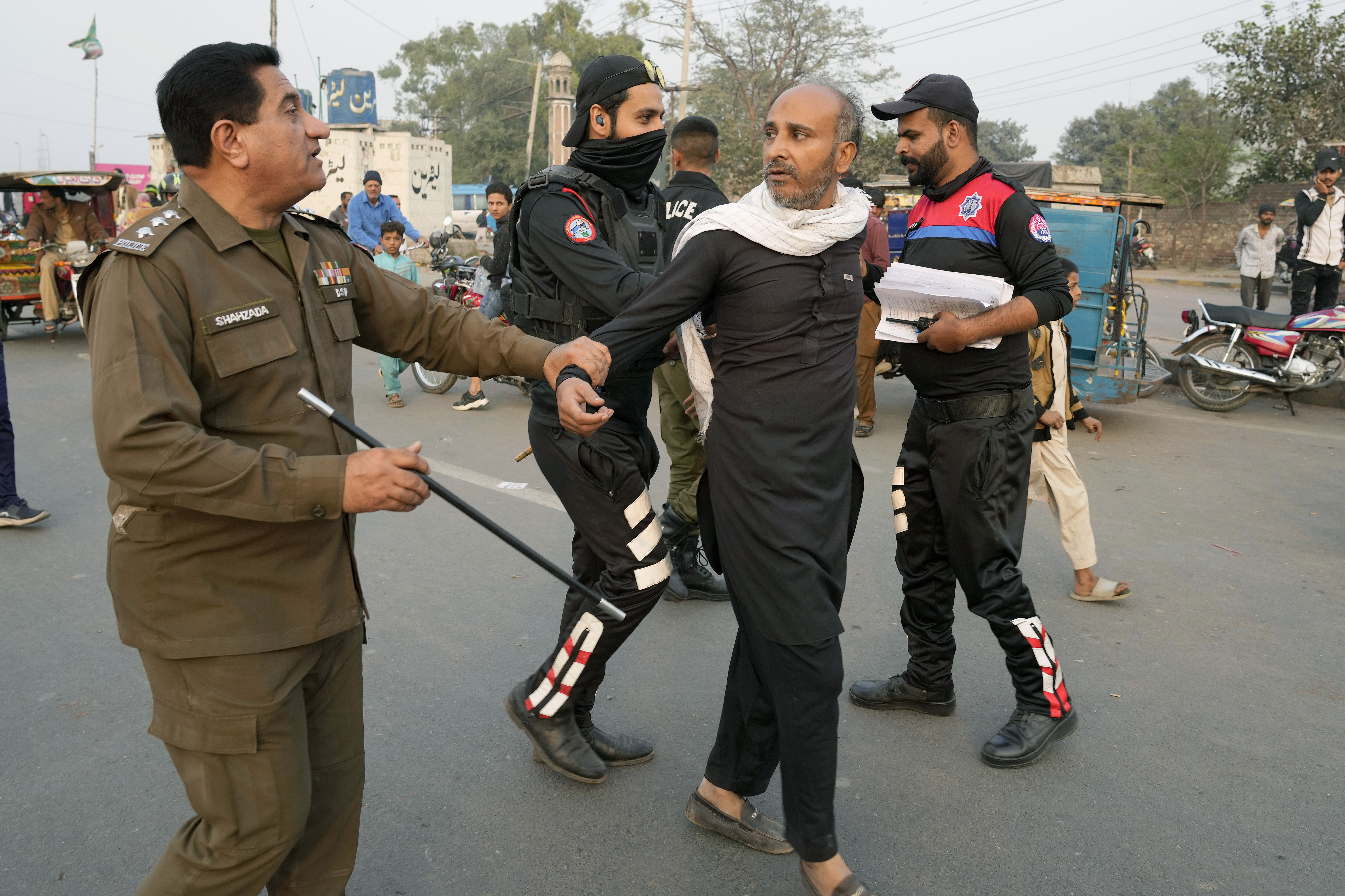 Police officers detain a supporter of imprisoned former premier Imran Khan's Pakistan Tehreek-e-Insaf party, which supporters gather for a rally demanding Khan's release, in Lahore, Pakistan, Sunday, Nov. 24, 2024. (AP Photo/K.M. Chaudary)