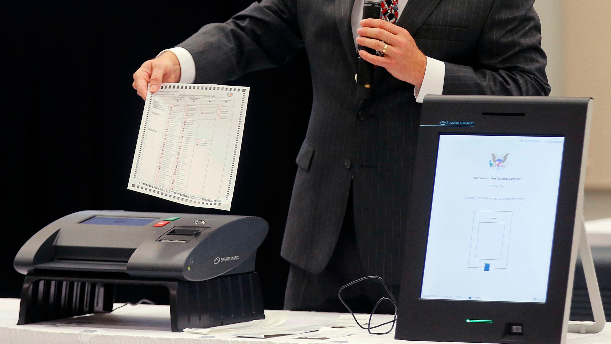 FILE - A Smartmatic representative demonstrates his company's system, which has scanners and touch screens with printout options, at a meeting of the Secure, Accessible & Fair Elections Commission, Aug. 30, 2018, in Grovetown, Ga. (Bob Andres/Atlanta Journal-Constitution via AP, File)