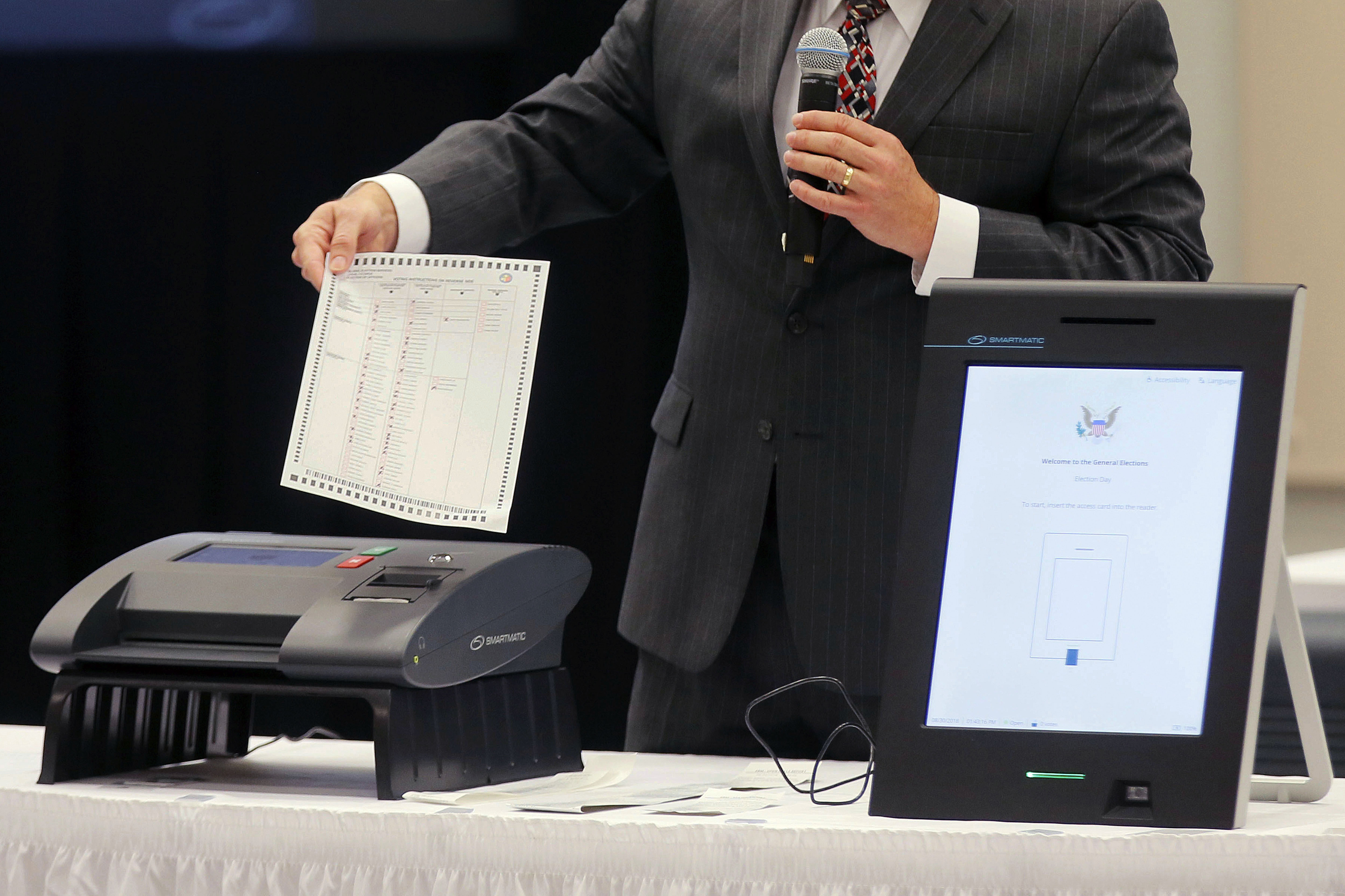 FILE - A Smartmatic representative demonstrates his company's system, which has scanners and touch screens with printout options, at a meeting of the Secure, Accessible & Fair Elections Commission, Aug. 30, 2018, in Grovetown, Ga. (Bob Andres/Atlanta Journal-Constitution via AP, File)