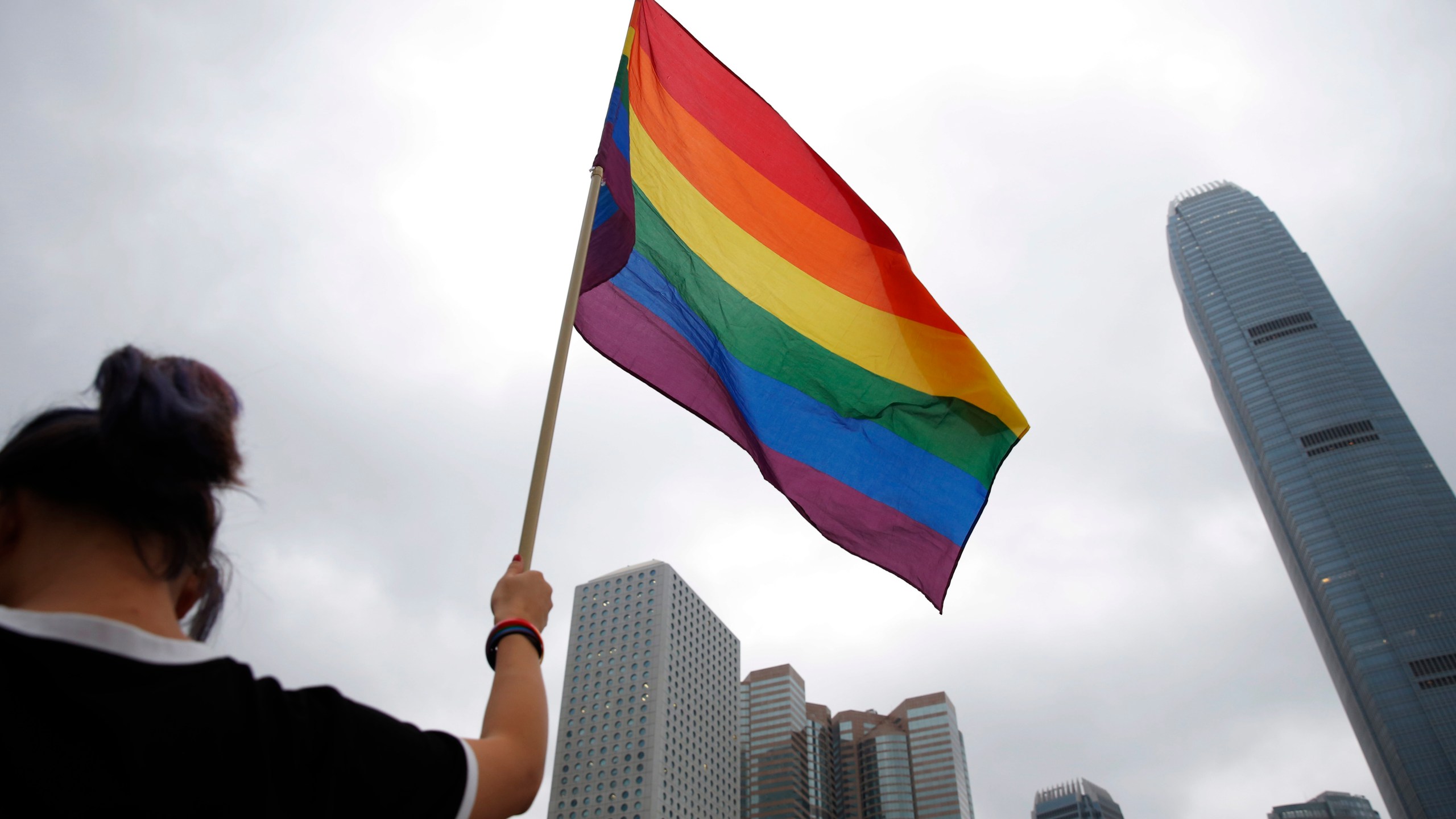 FILE - A participant holds a rainbow flag at the annual Pride Parade in Hong Kong, Nov. 17, 2018. (AP Photo/Kin Cheung, File)