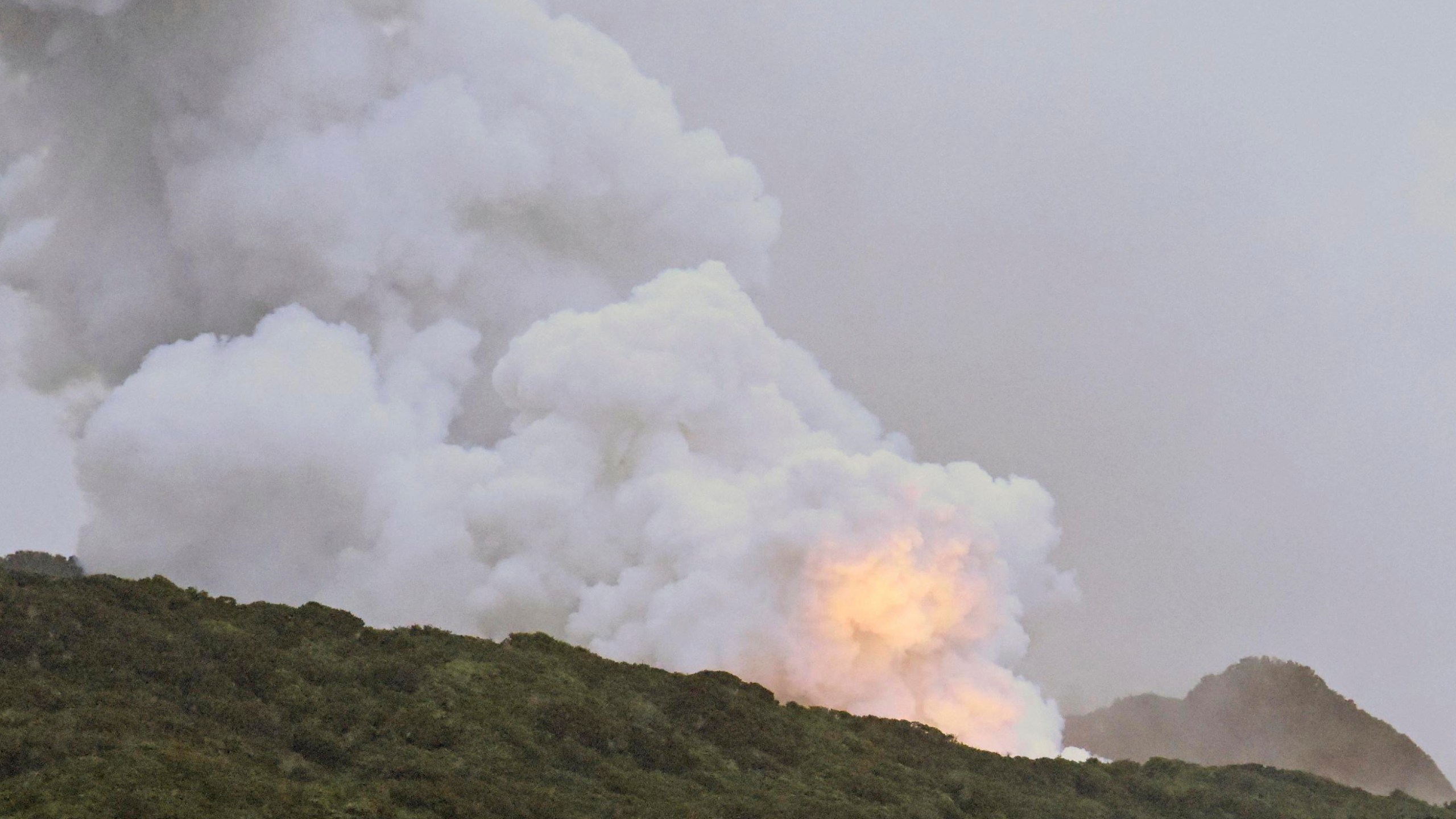 Smoke and fire is seen during a combustion test of an engine for a new small Japanese rocket Epsilon S at Tanegashima Space Center, Kagoshima prefecture, southern Japan, Tuesday, Nov. 26, 2024. (Kyodo News via AP)