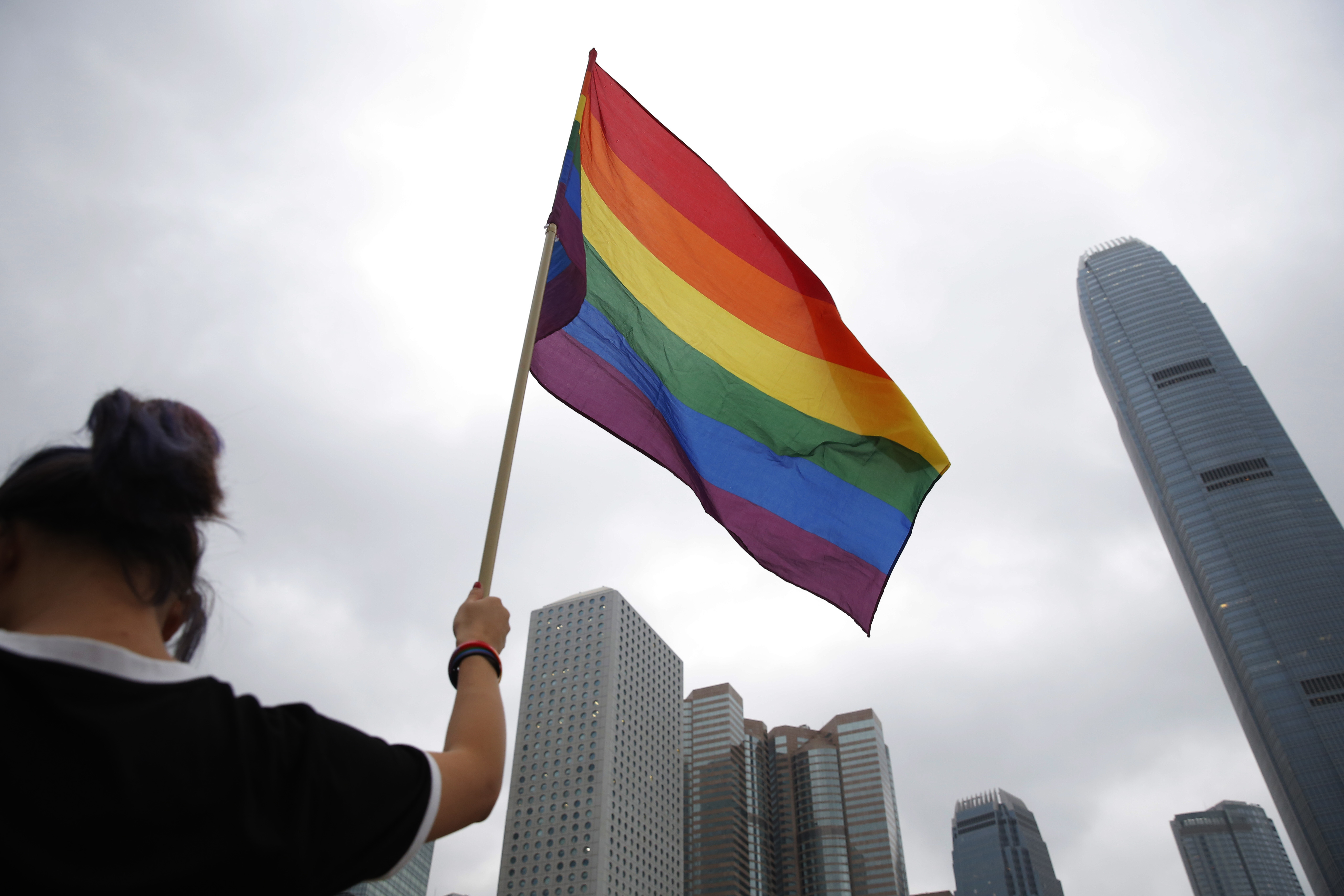 FILE - A participant holds a rainbow flag at the annual Pride Parade in Hong Kong, Nov. 17, 2018. (AP Photo/Kin Cheung, File)