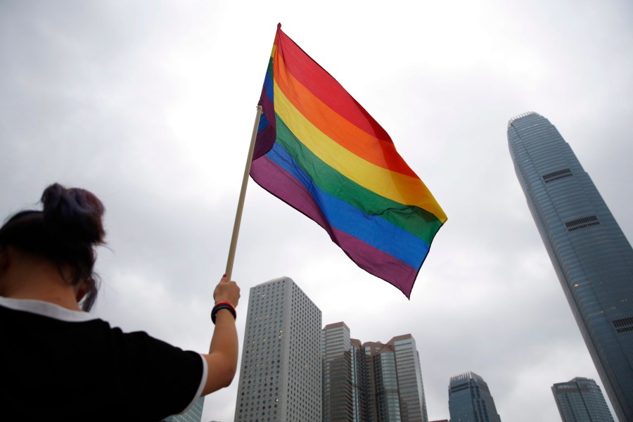 FILE - A participant holds a rainbow flag at the annual Pride Parade in Hong Kong, Nov. 17, 2018. (AP Photo/Kin Cheung, File)