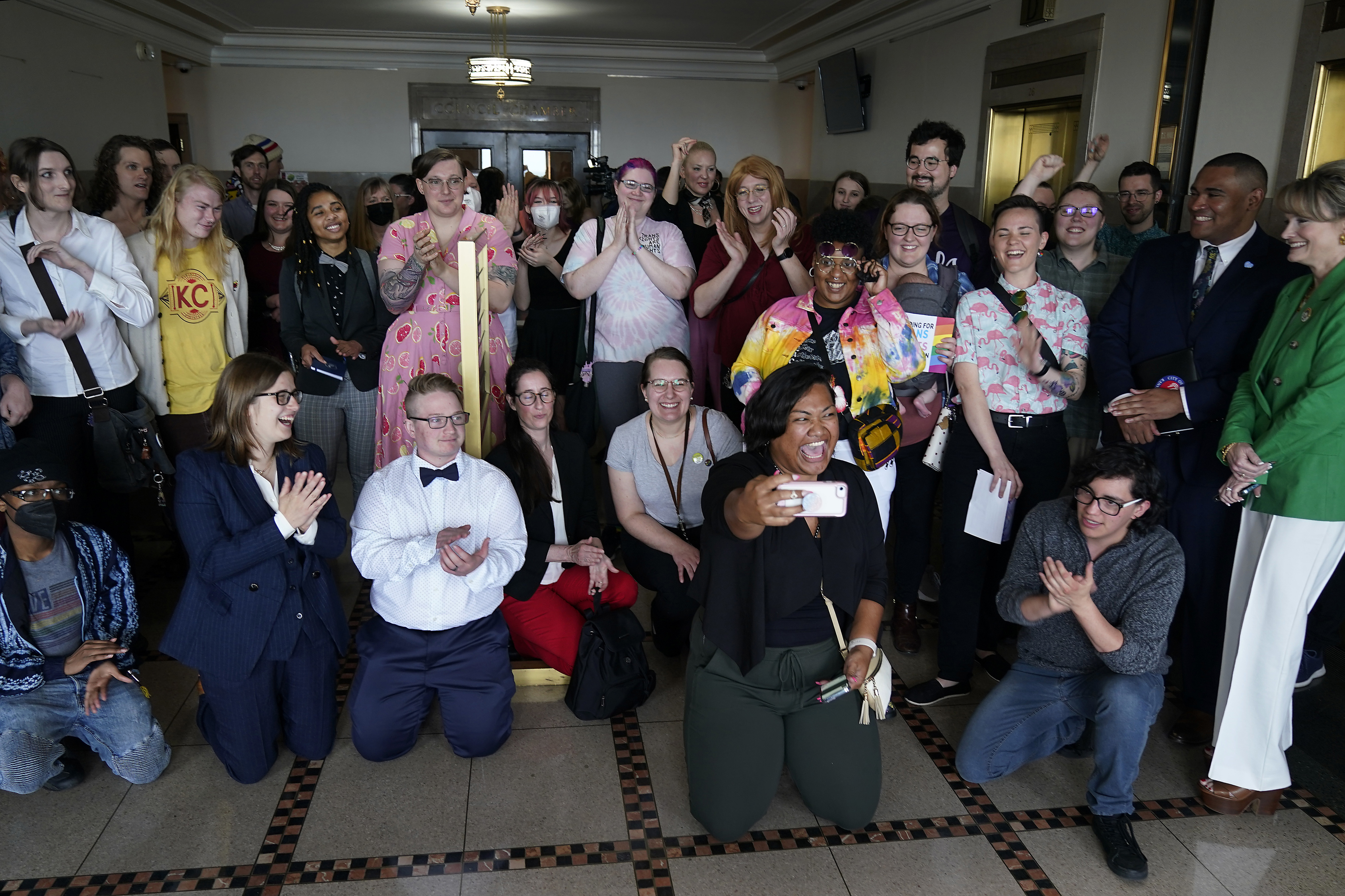 FILE - Supporters of a resolution that would make Kansas City, Mo, a sanctuary city for transgender people celebrate outside of city council chambers after a committee approved the resolution, sending it to the full council for consideration, Wednesday, May 10, 2023, in Kansas City, Mo. (AP Photo/Charlie Riedel, File)