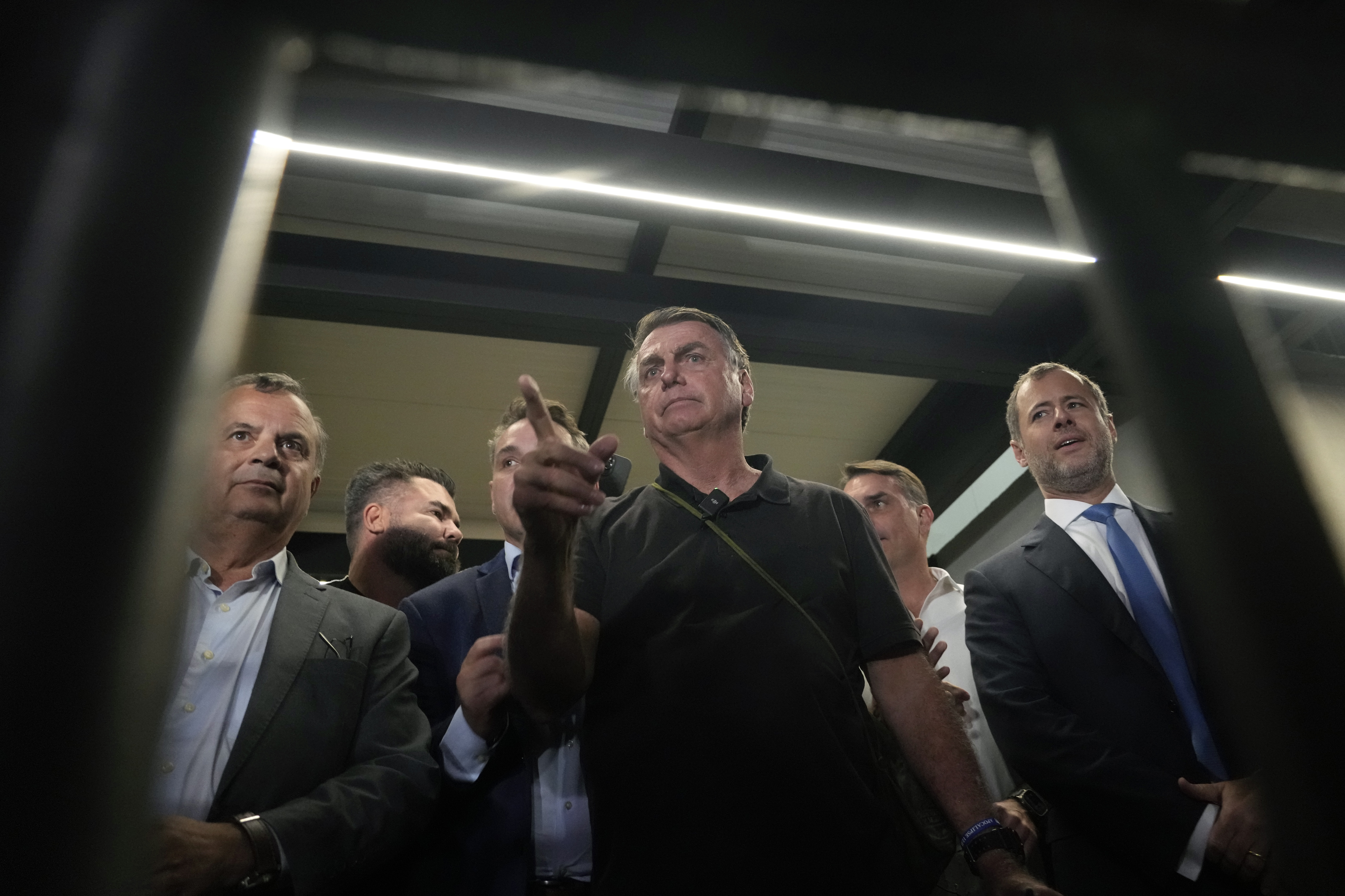 Former President Jair Bolsonaro arrives to speak with the press after being formally charged by the federal police with attempted coup, at the airport in Brasilia, Brazil, Monday, Nov. 25, 2024. (AP Photo/Eraldo Peres)